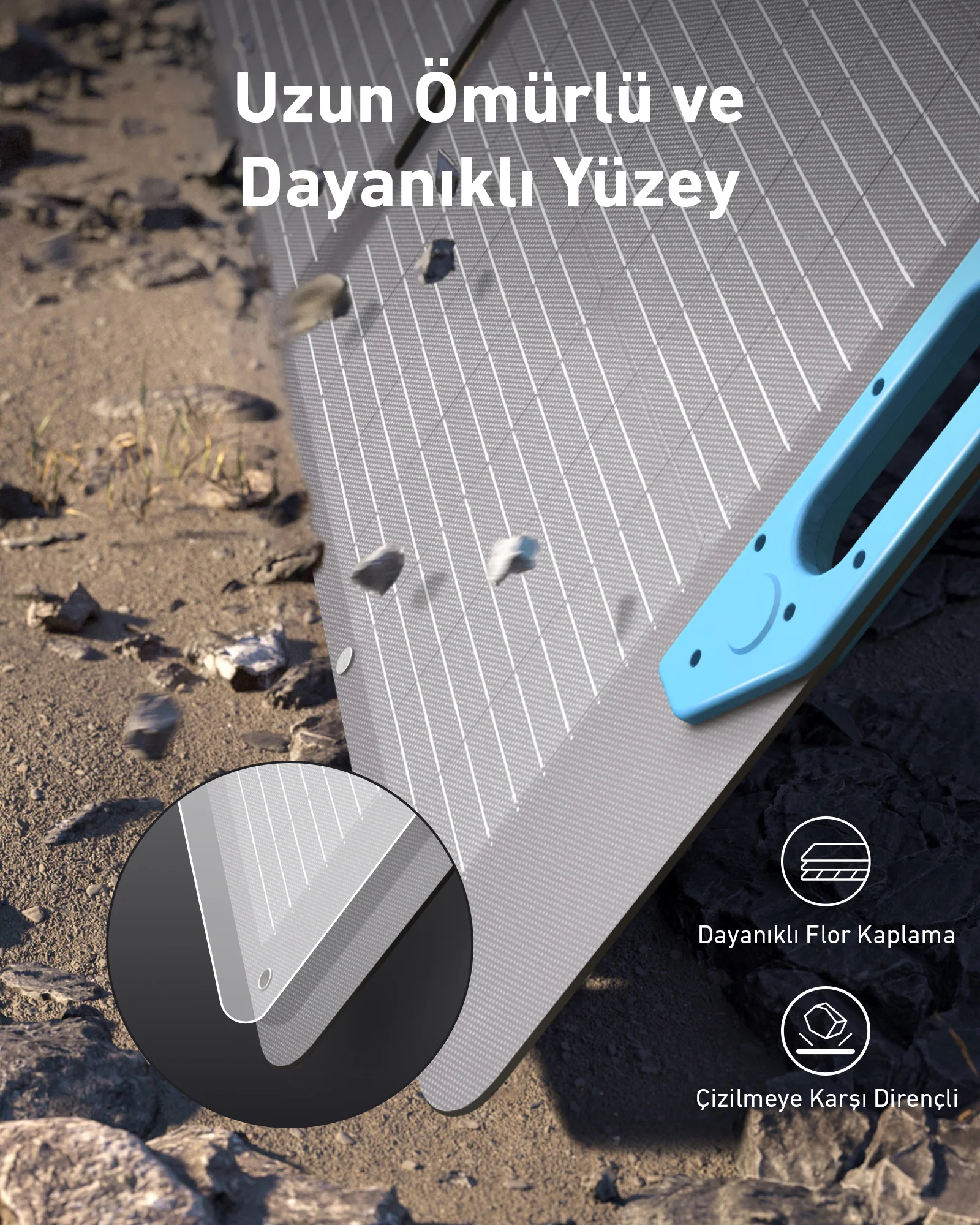 Mavi bir tutamağa sahip gri bir yüzey, küçük taşlarla çevrili, dayanıklılık ve çizilme direnci gösteriyor.