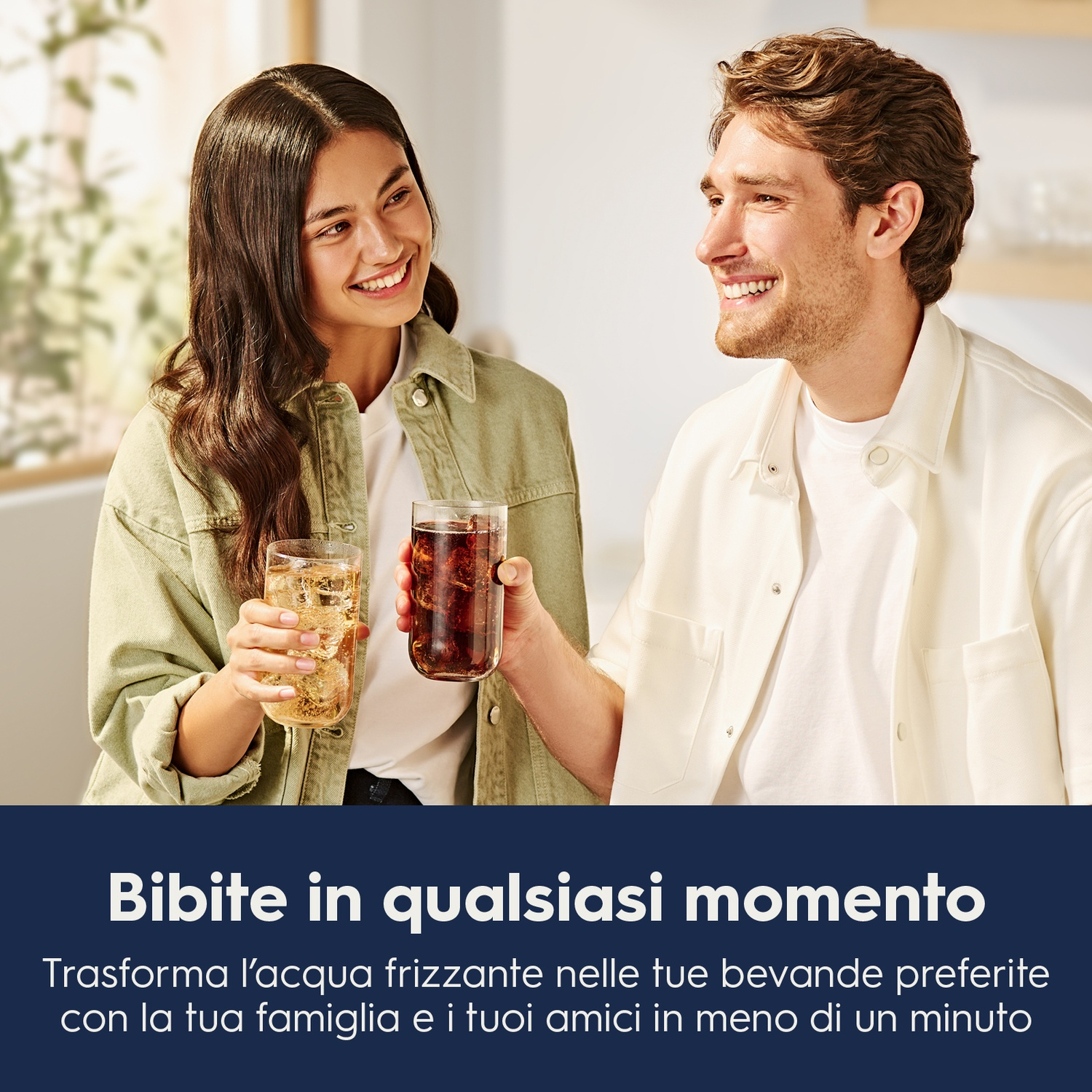 Una coppia sorride mentre tiene in mano bicchieri di bevande. Testo: 'Bevande in qualsiasi momento'.