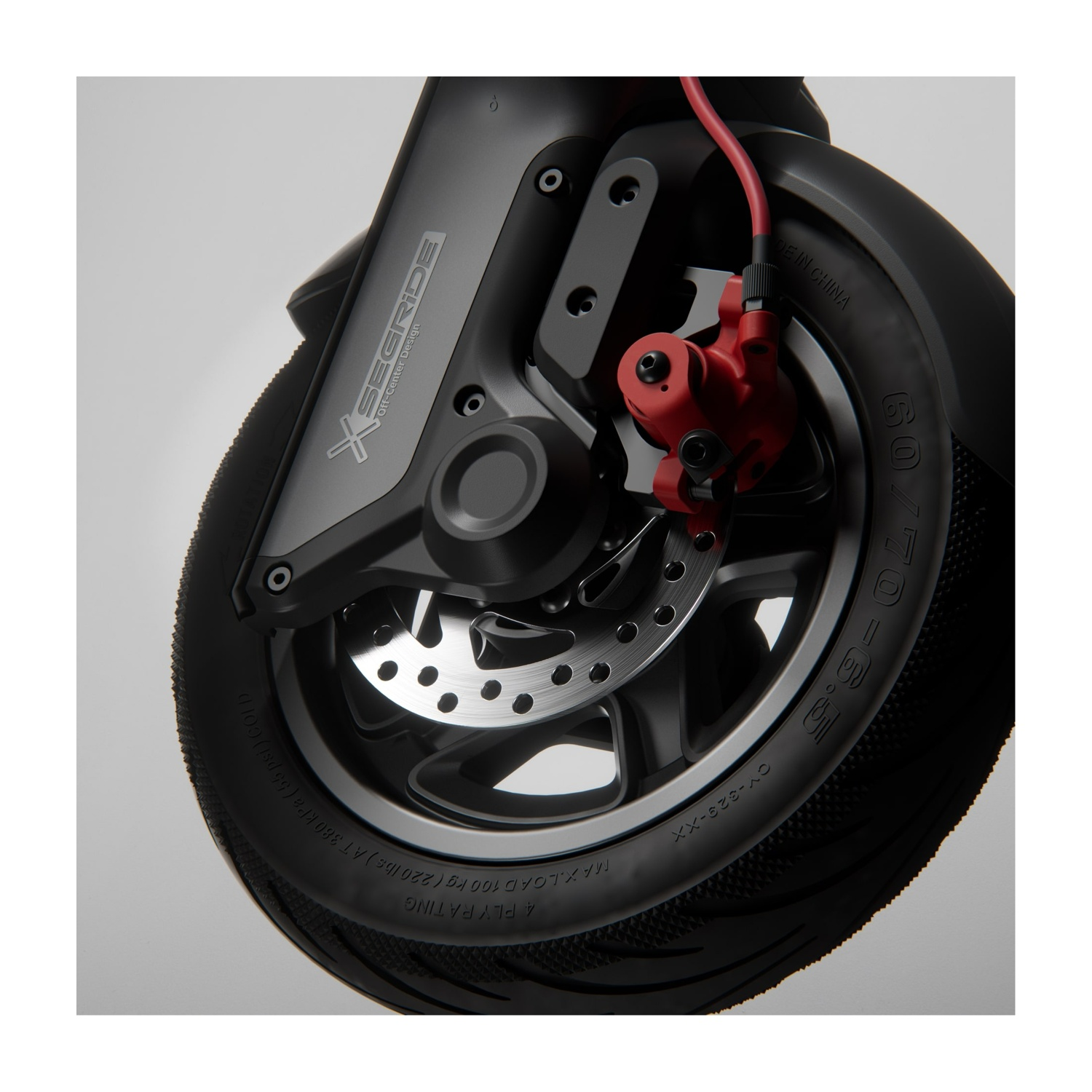Dettaglio ruota scooter Segway Ninebot F3. Freno rosso, pneumatico nero, dettagli grigi. B.