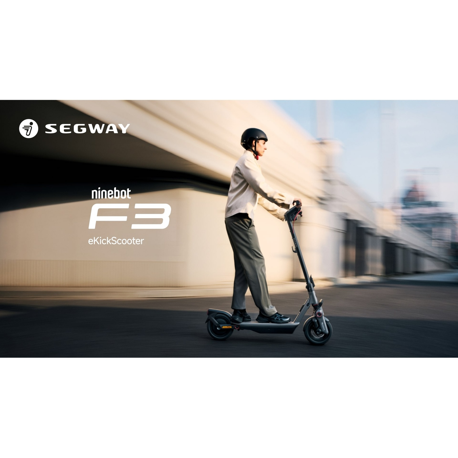 Persona che guida Segway Ninebot F3 eKickScooter. Uomo con casco, su una strada cittadina.