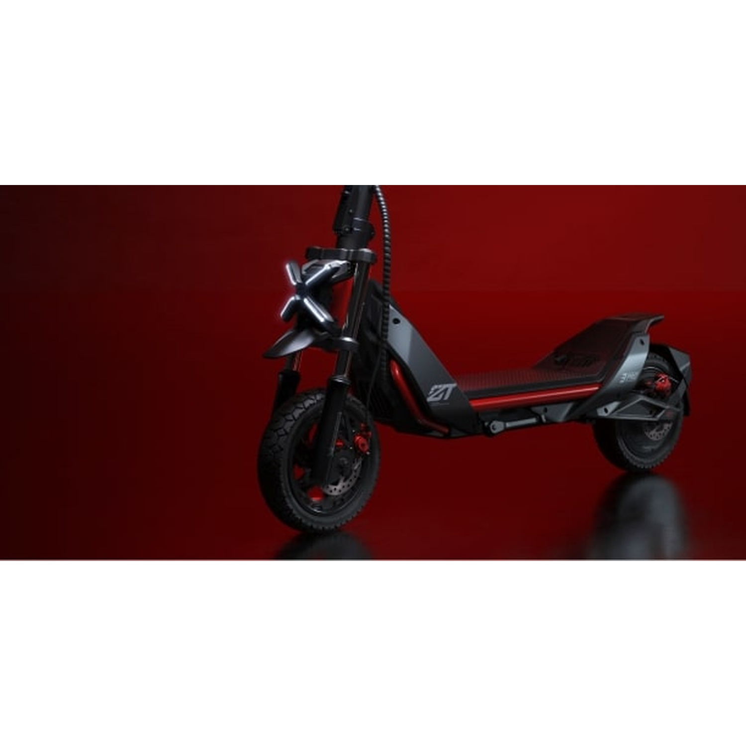 Scooter elettrico nero e grigio con dettagli rossi, su sfondo rosso.