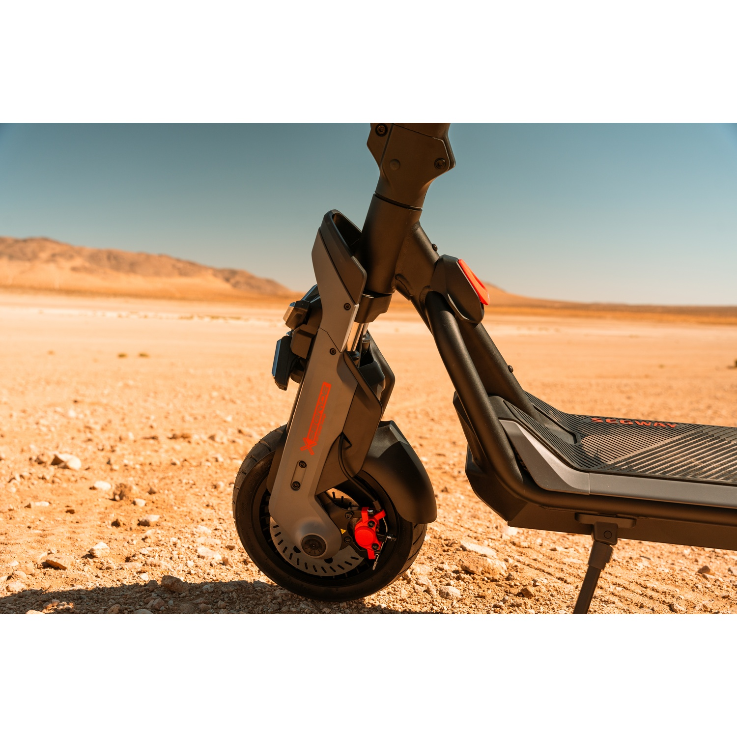 Ruota dello scooter elettrico su un paesaggio desertico con cielo blu.