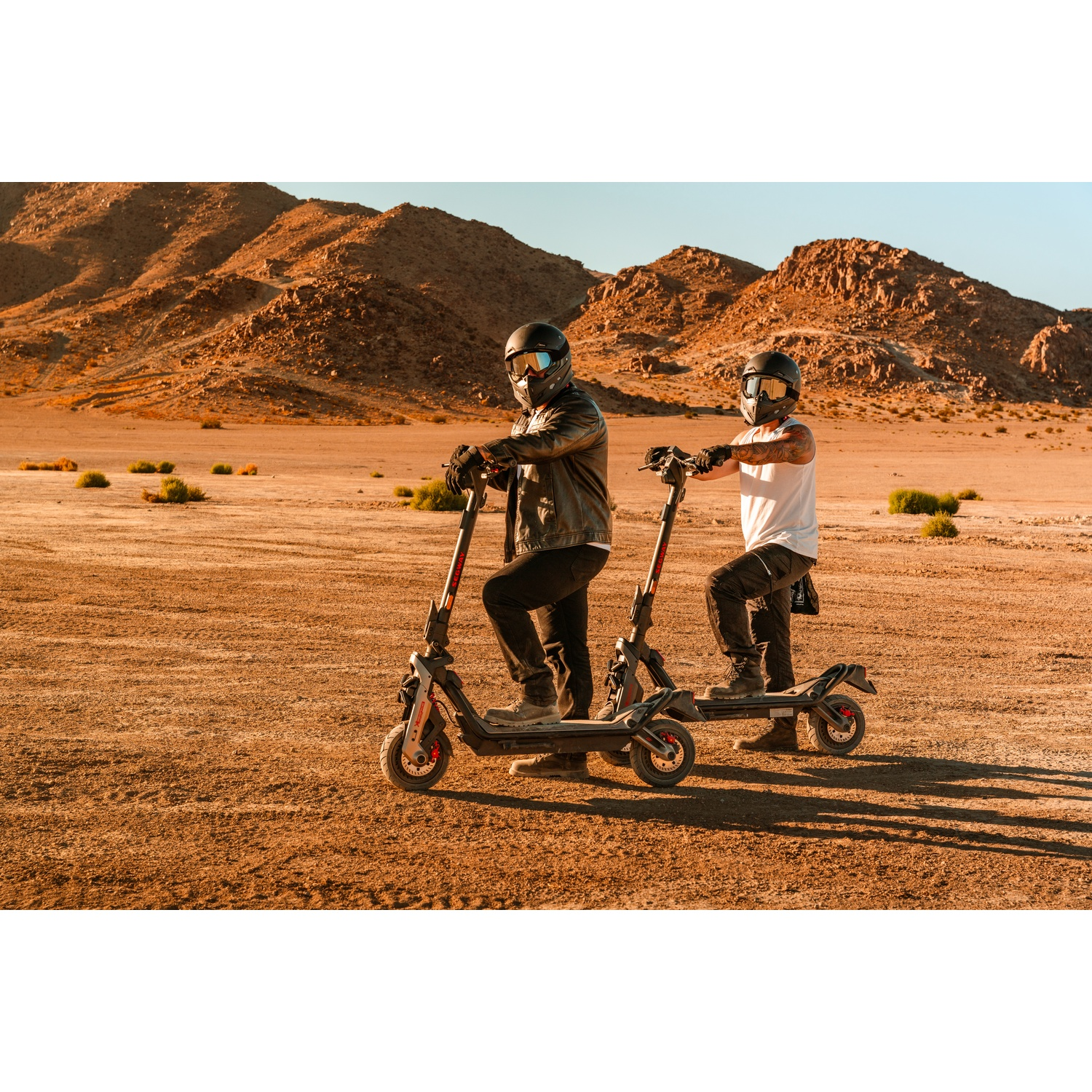 Due persone su scooter in un paesaggio desertico.