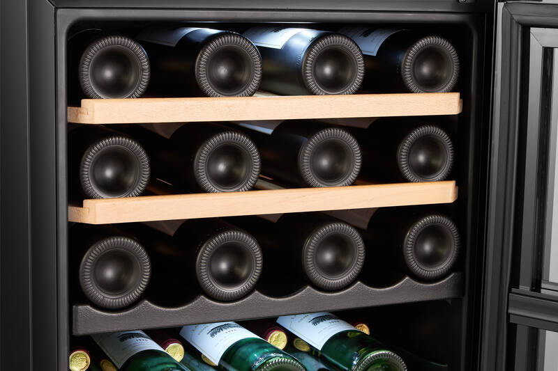 Bottiglie di vino in una cantinetta, tre ripiani di bottiglie visibili. Interno scuro, primo piano.