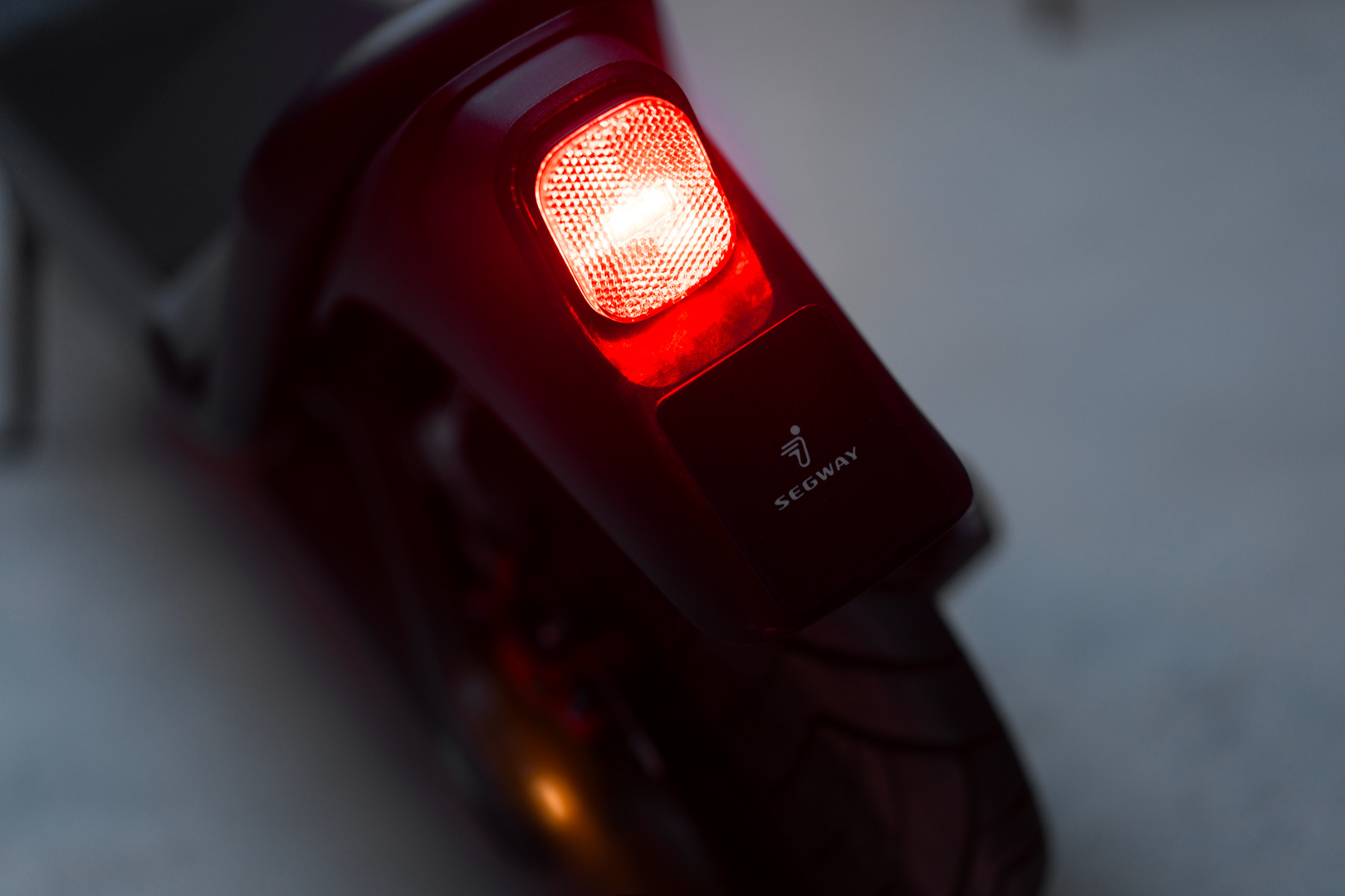 Gros plan du feu arrière rouge d'une trottinette. Le logo Segway est visible.