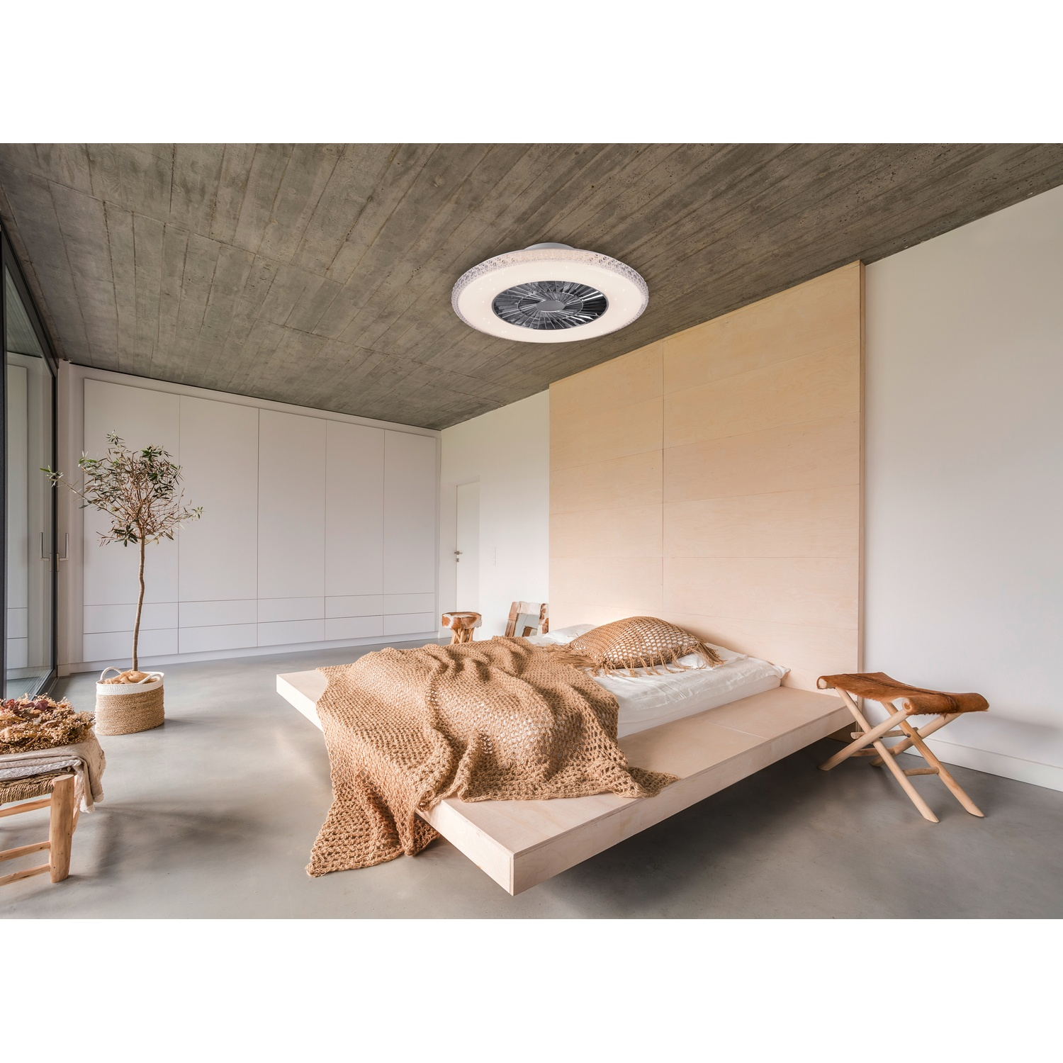 Una camera da letto con un ventilatore da soffitto bianco, un letto ed elementi in legno chiaro.