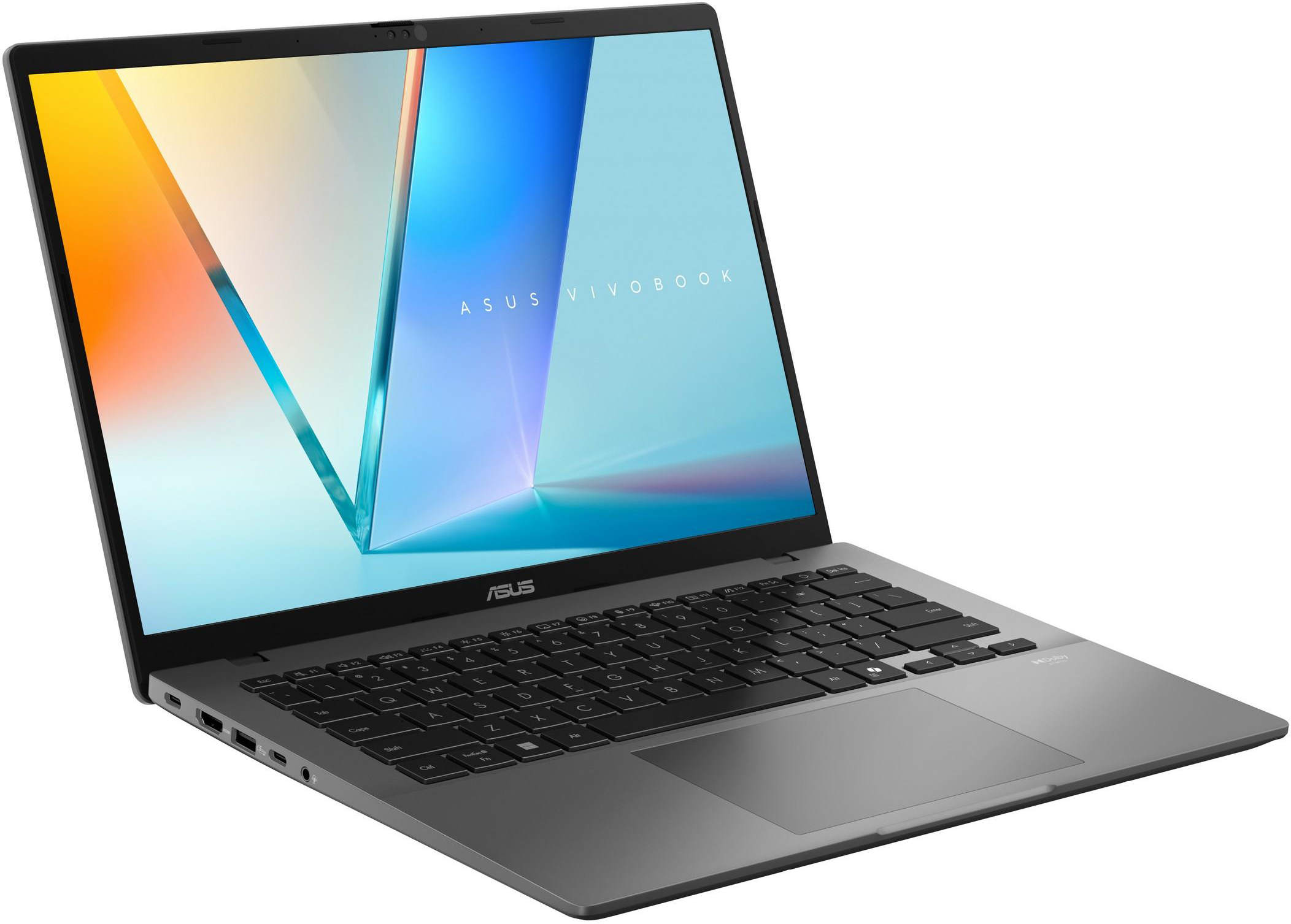 Szürke laptop, szögből. A képernyő absztrakt képet mutat. Billentyűzet és touchpad látható.