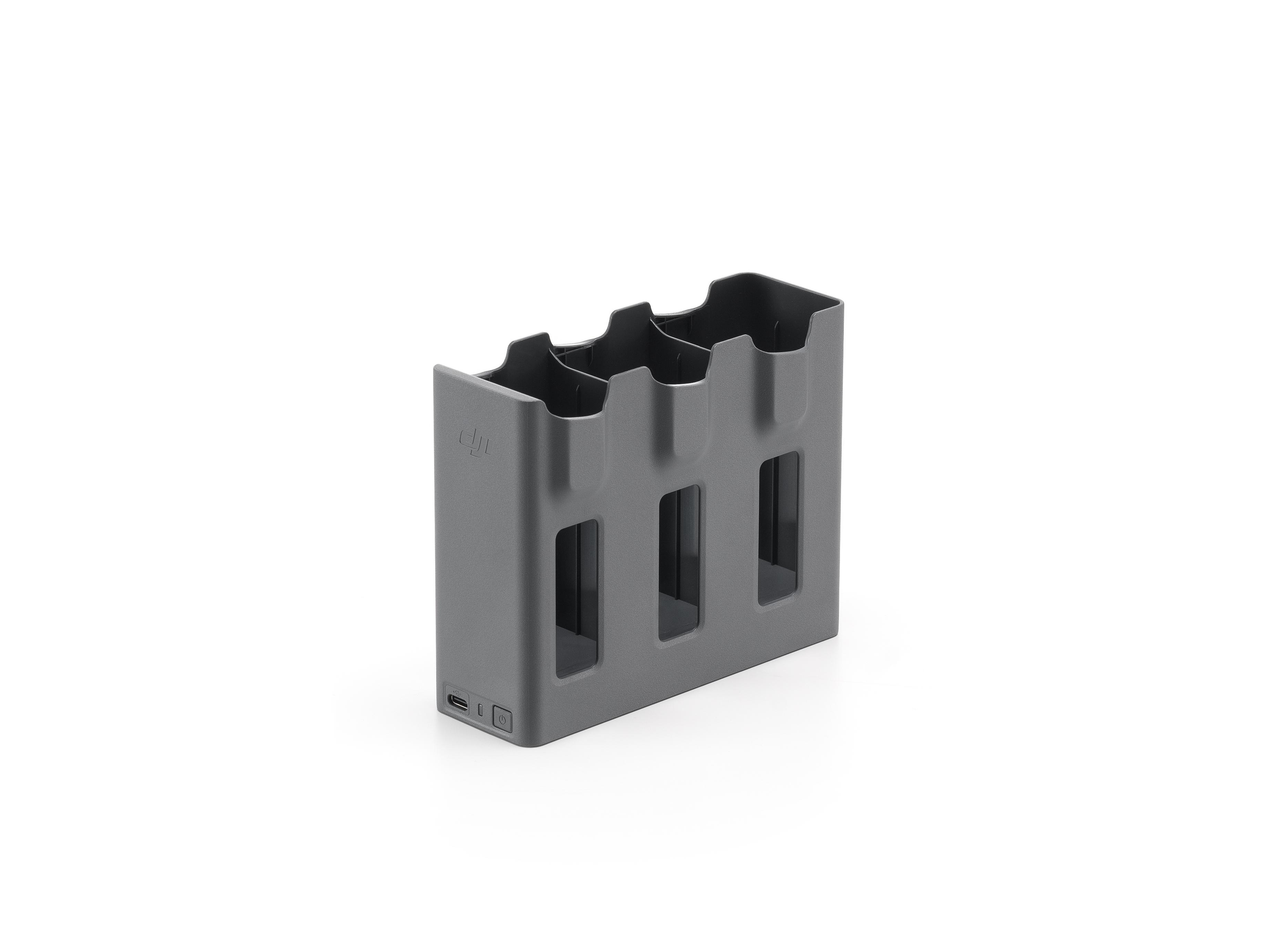 Grauer Ladehub für drei Batterien mit sichtbarem USB-Anschluss, auf weißem Hintergrund.
