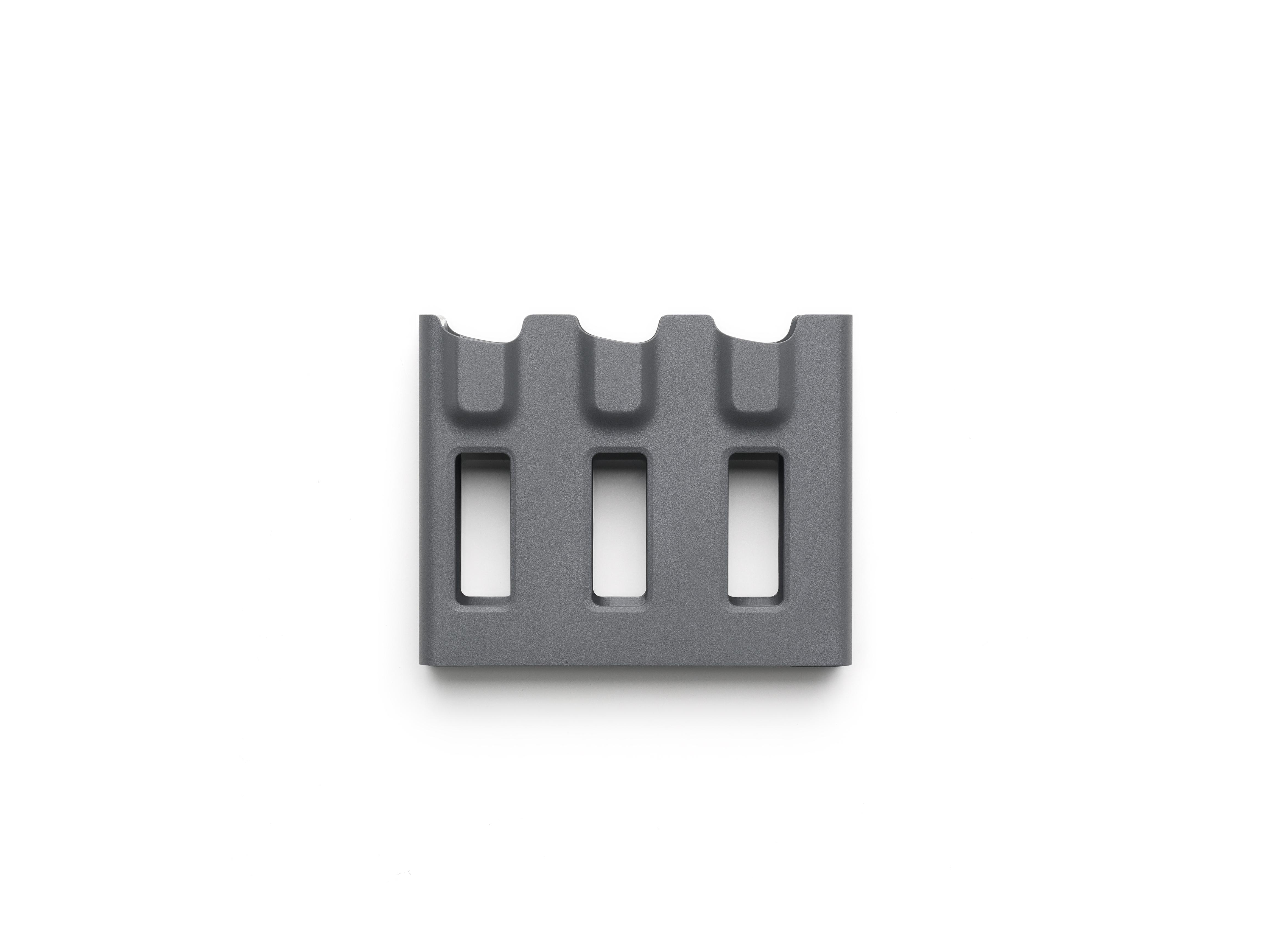Grauer Ladehub für drei Batterien, Draufsicht, auf weißem Hintergrund.