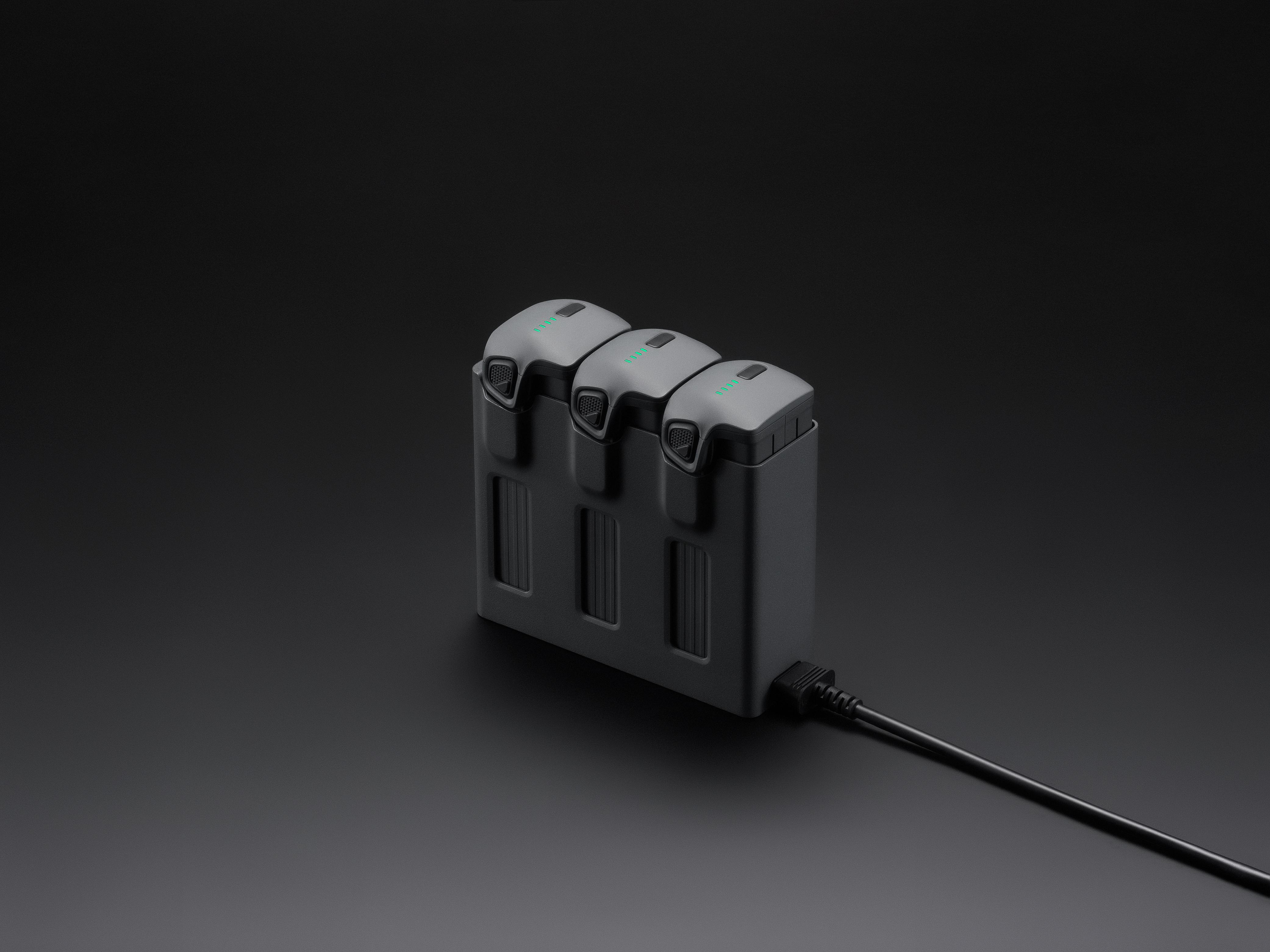 Lade-Hub mit drei angeschlossenen Batterien und Kabel auf dunklem Hintergrund.