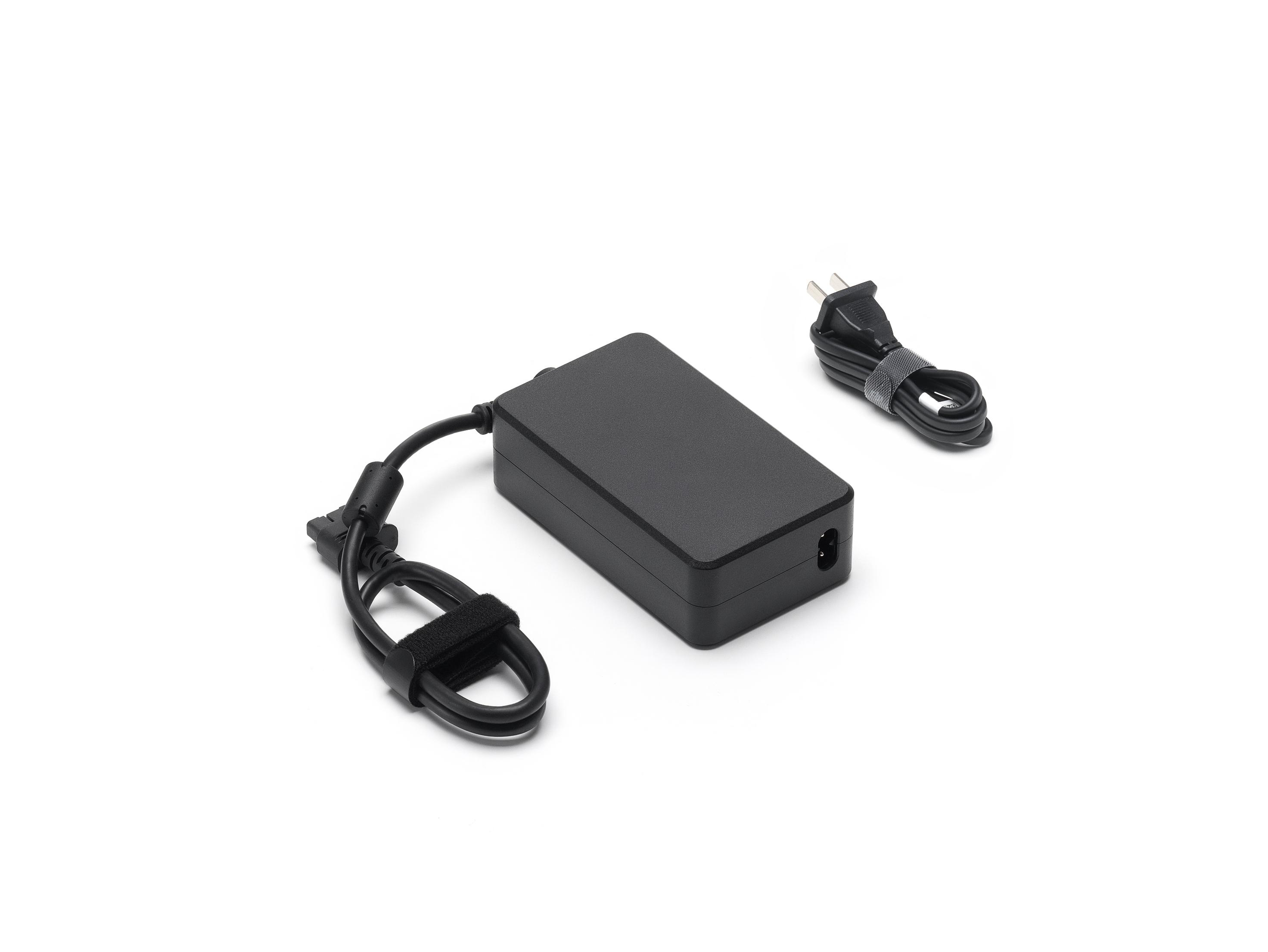Schwarzes Netzteil mit Kabel, weißer Hintergrund.