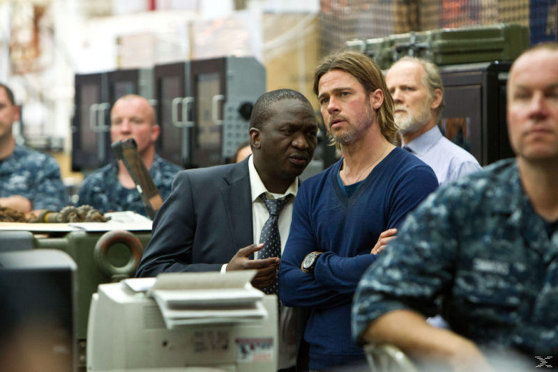 Brad Pitt mit einem Mann im Anzug. Andere Personen in Uniform sind im Hintergrund.