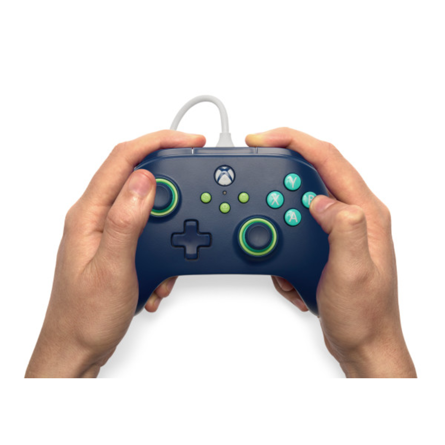 Hands holding a dark blue Xbox controller. Green accents on thumbsticks and buttons. White cable. White background.