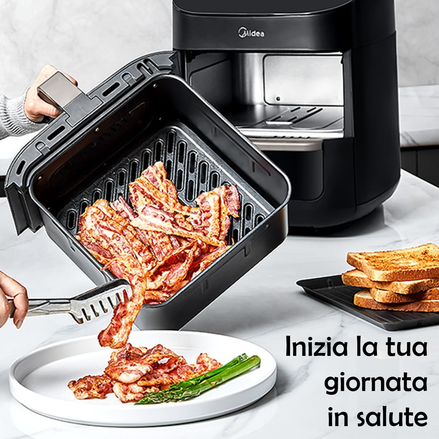 Pancetta viene impiattata da una friggitrice ad aria. Toast e asparagi sono sul piatto e sul bancone.