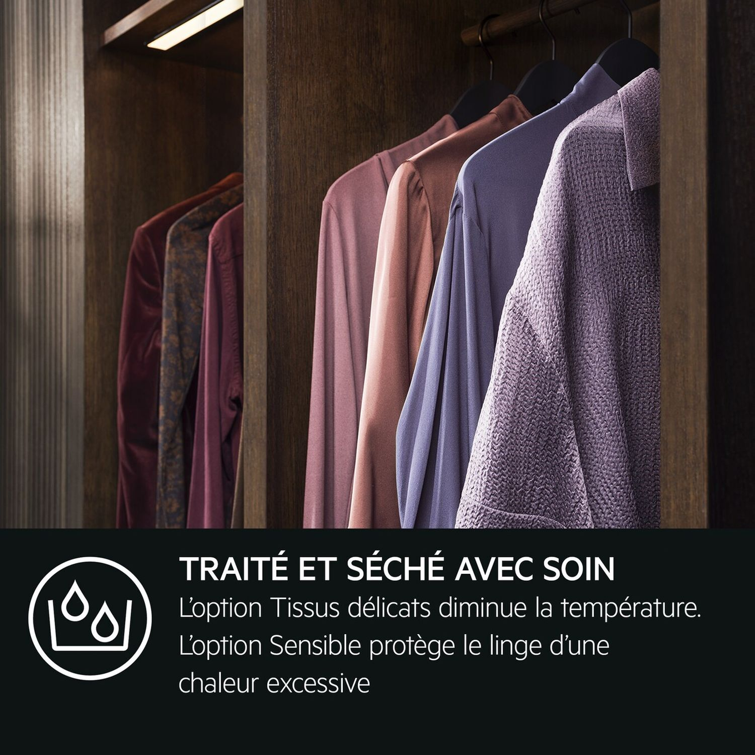 Vêtements suspendus dans un placard. Différentes couleurs. Fond en bois foncé.