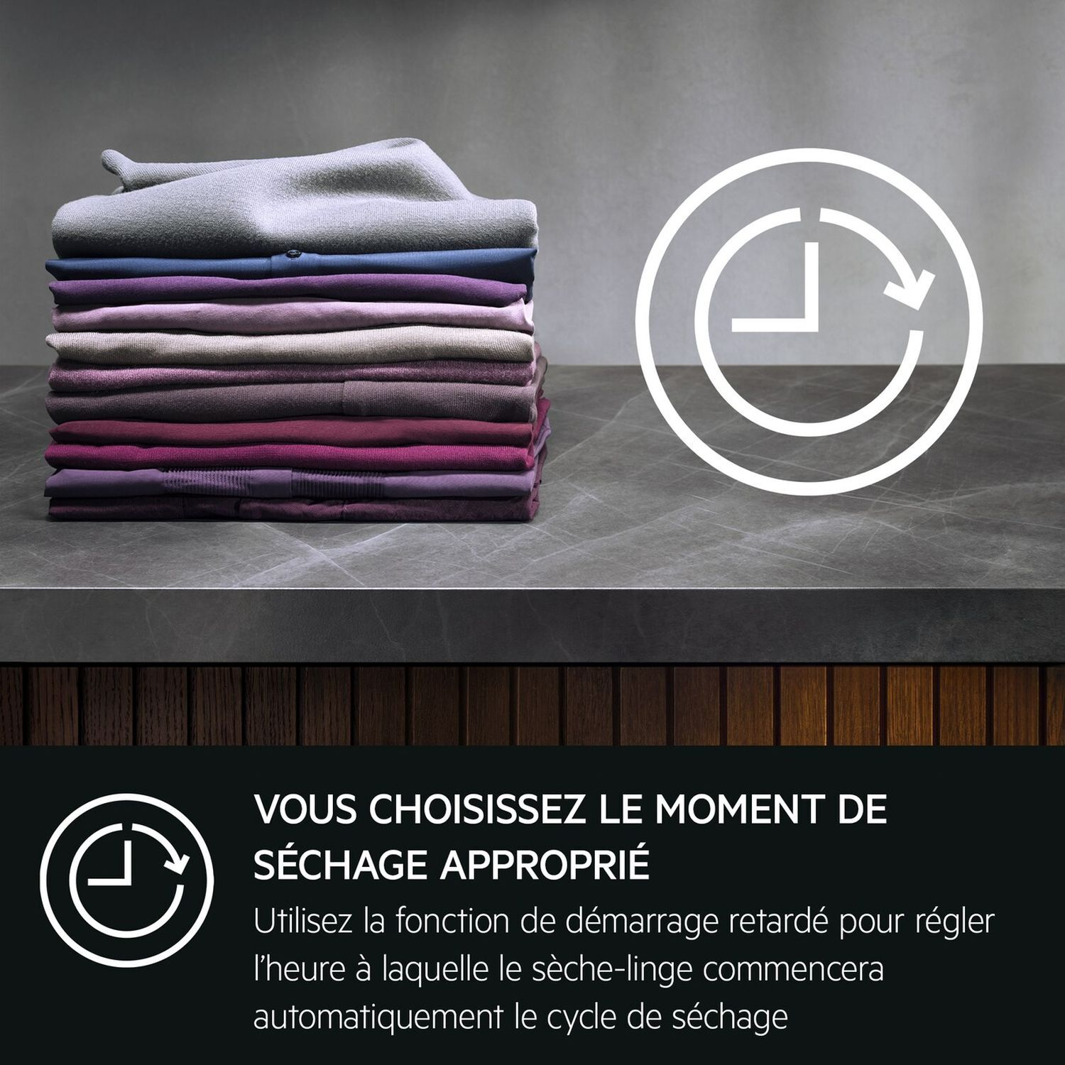 Vêtements pliés sur une surface. Une icône de minuterie. Fond en bois sombre et pierre.