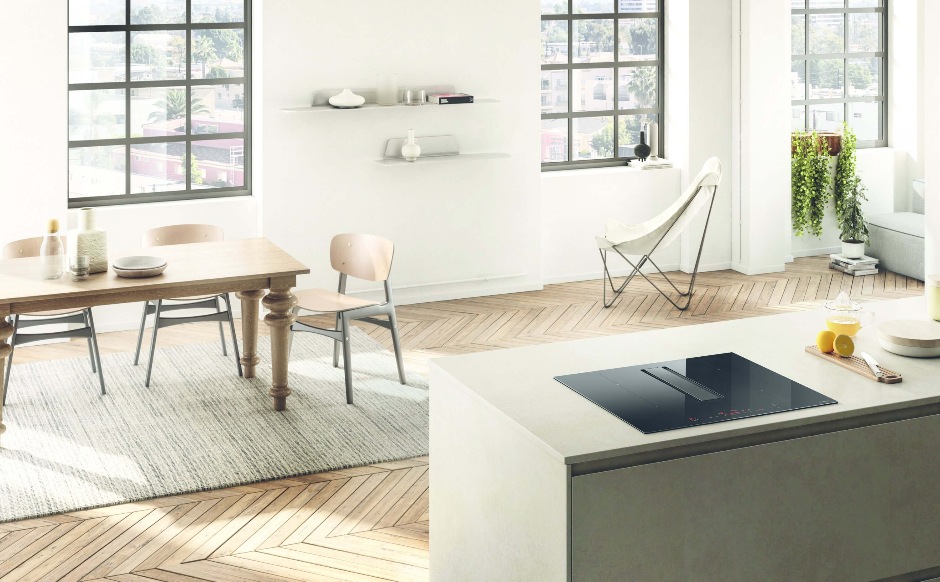 Nowoczesna kuchnia z czarną płytą grzewczą, jadalnią i dużymi oknami. Jasna, otwarta przestrzeń.