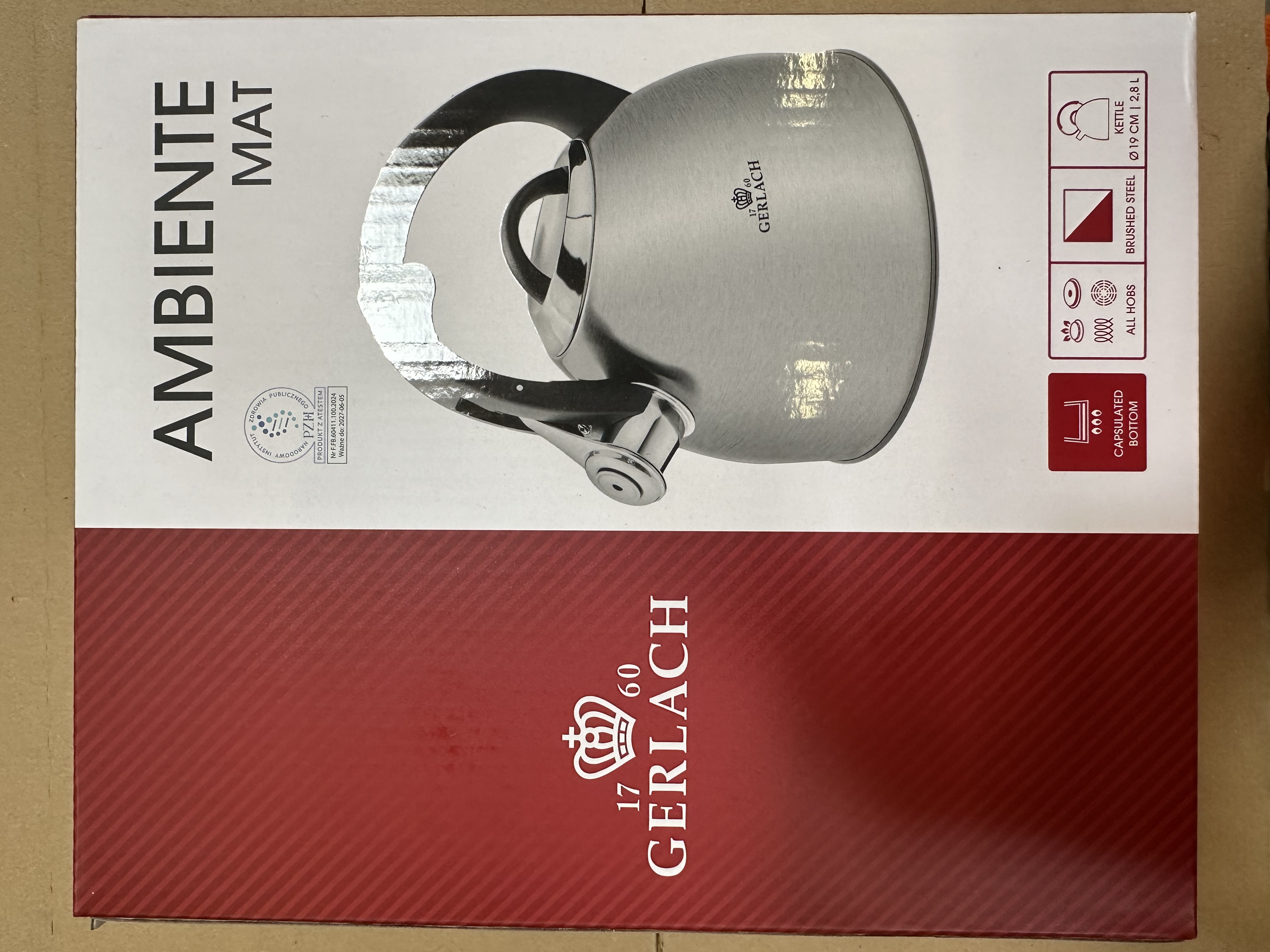 Czajnik na pudełku, z tekstem "AMBIENTE MAT" i innymi szczegółami.