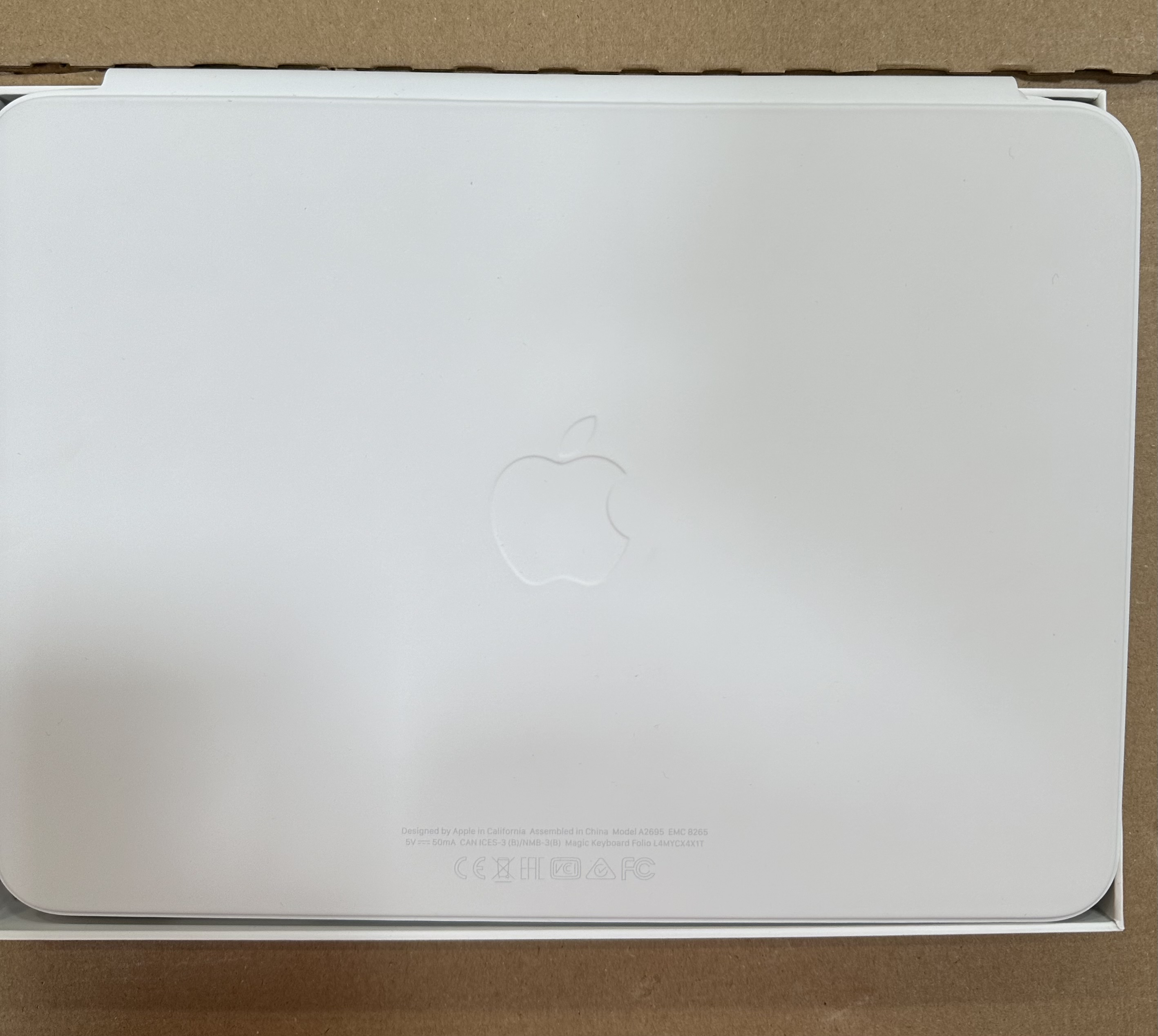 Tył białego iPad Magic Keyboard Folio. Logo Apple pośrodku. Białe tło.
