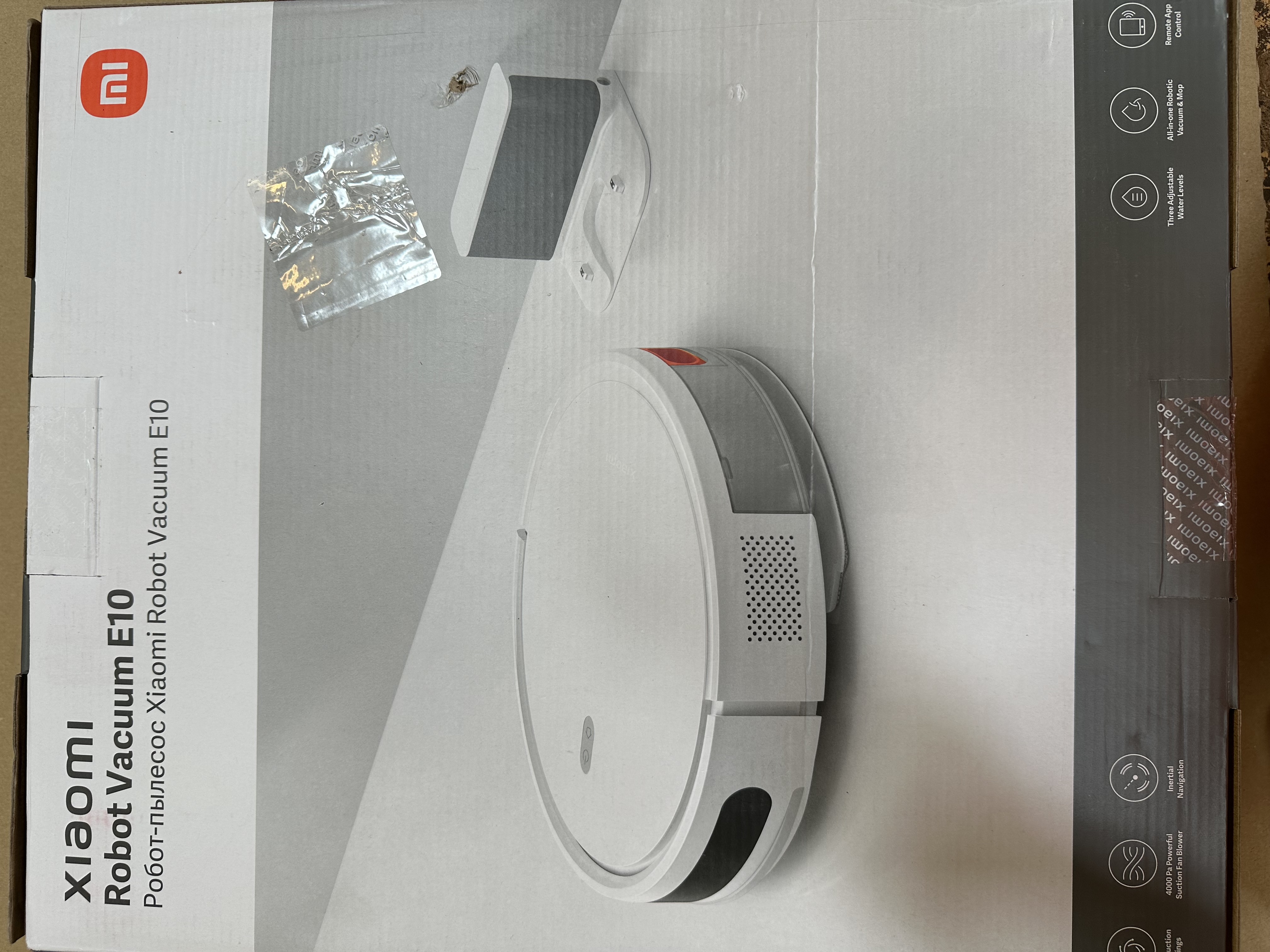 Odkurzacz robot w pudełku. Pudełko jest białe i ma tekst oraz obrazy.