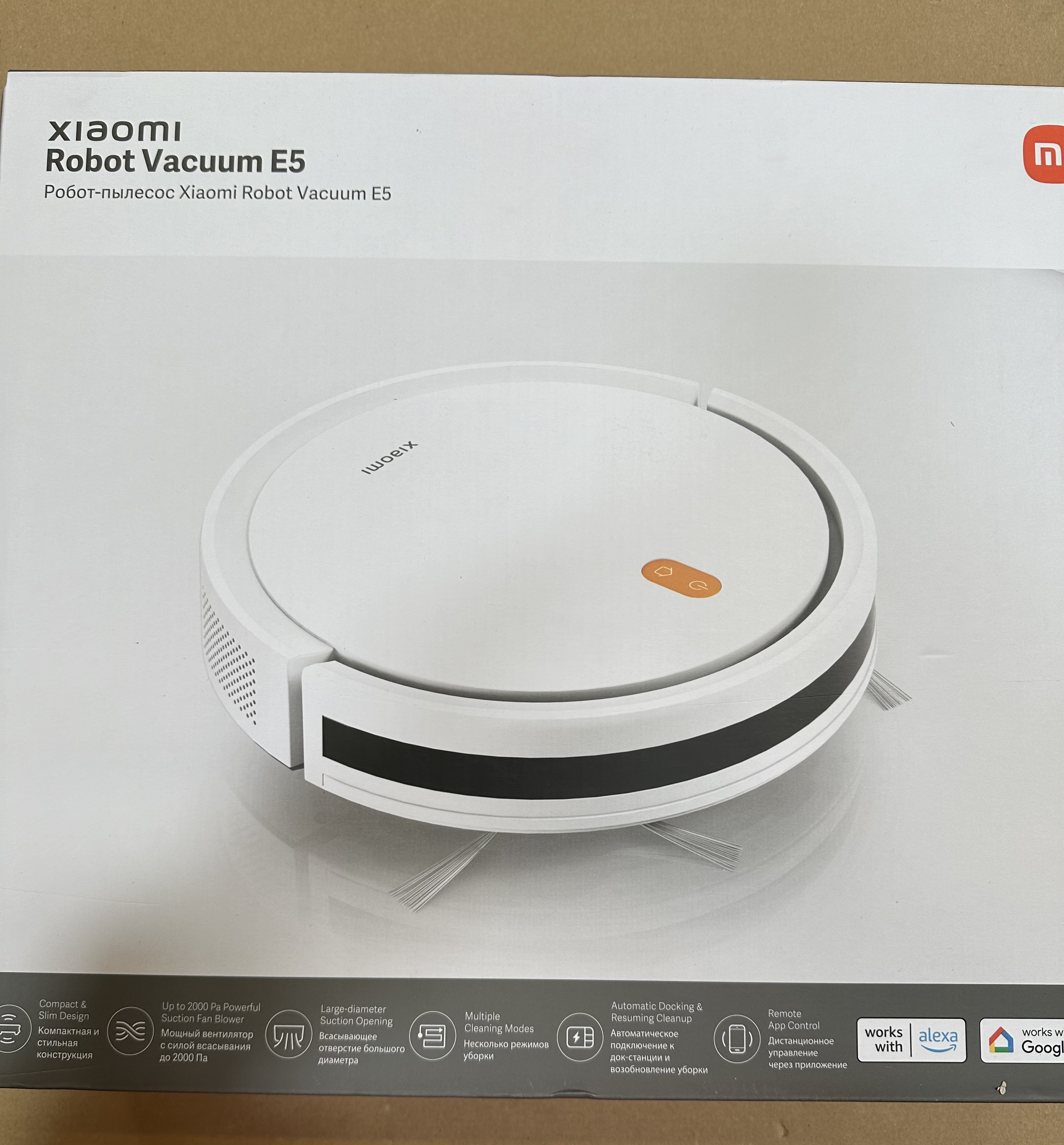 Pudełko odkurzacza robota z tekstem i obrazami. Odkurzacz jest biały.