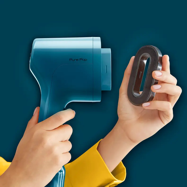 Osoba trzymająca niebieski parownik do tkanin i czarny element na niebieskim tle.