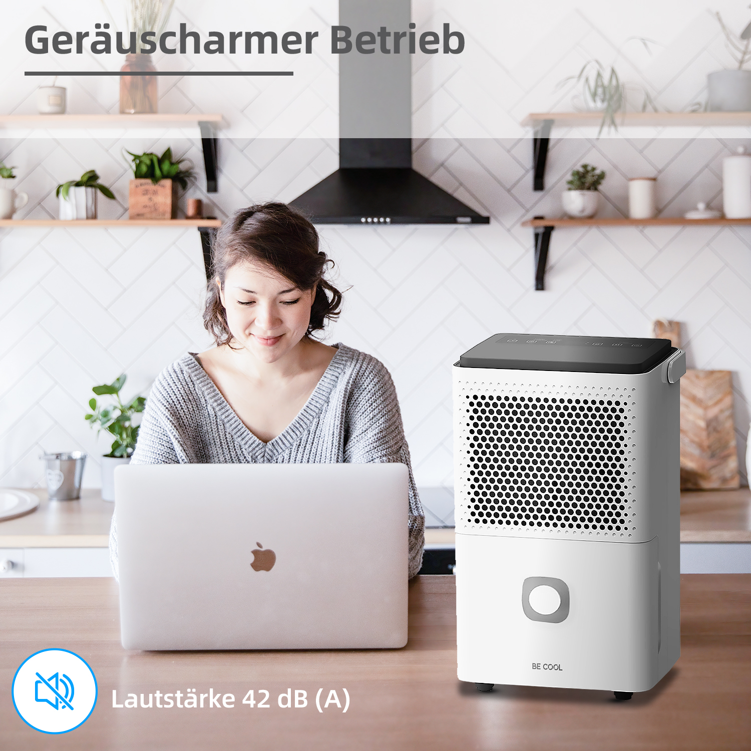 Eine Frau benutzt einen Laptop mit einem Luftentfeuchter. Der Luftentfeuchter ist weiß und neben der Frau.