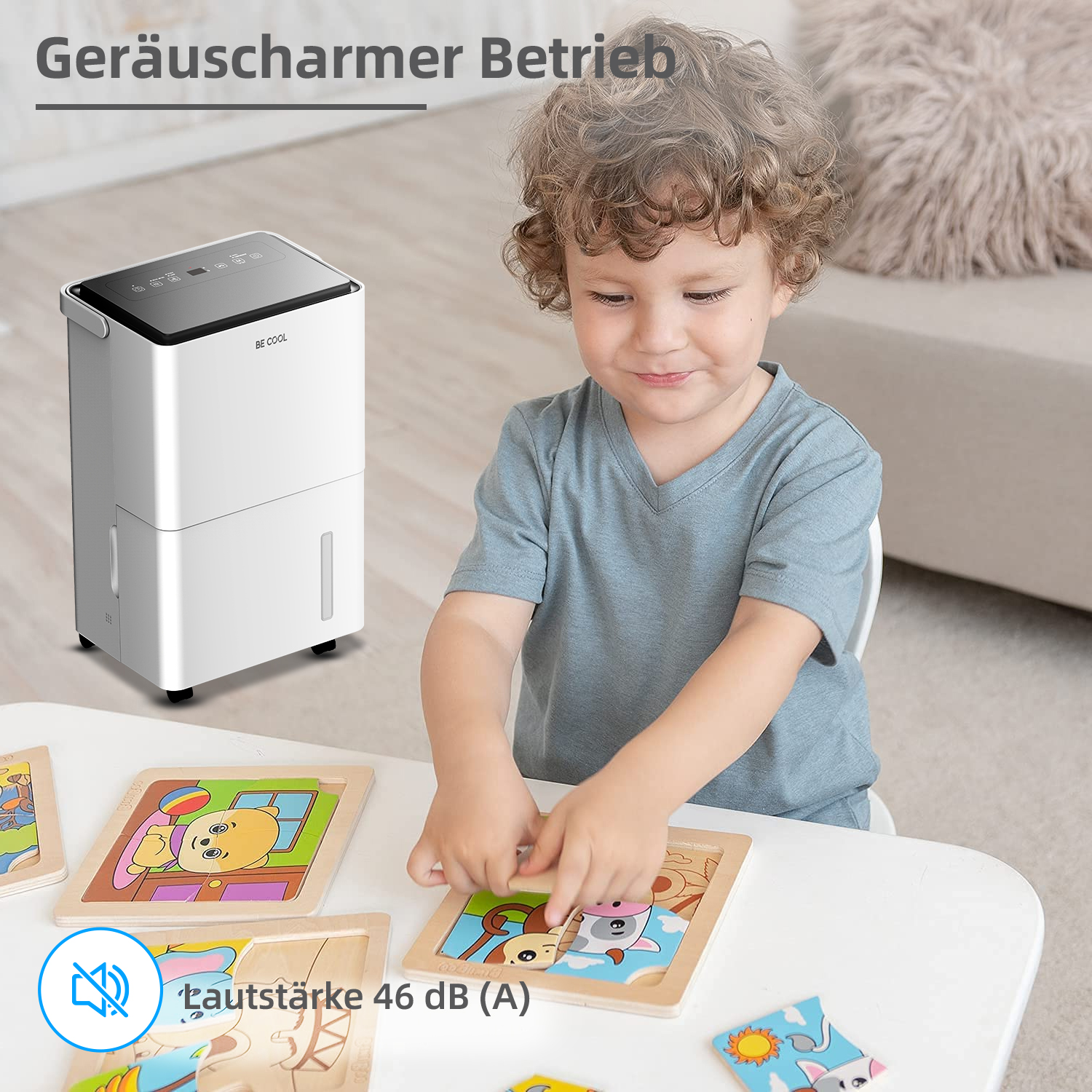 Ein Junge spielt mit Puzzles in der Nähe eines weißen Luftentfeuchters. Der Text lautet 'Geräuscharmer Betrieb' und '46 dB (A)'.