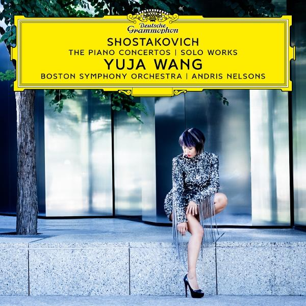 Albumcover: Yuja Wang, Schostakowitsch, Klavierkonzerte. Frau im Paillettenkleid, Stadtkulisse.