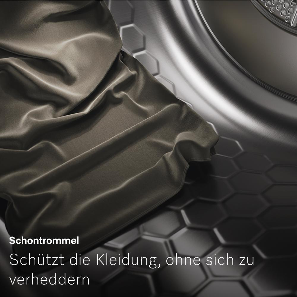 Nahaufnahme einer Waschmaschinentrommel mit Stoff darin. Text sagt: Schützt die Kleidung, ohne sich zu verheddern.