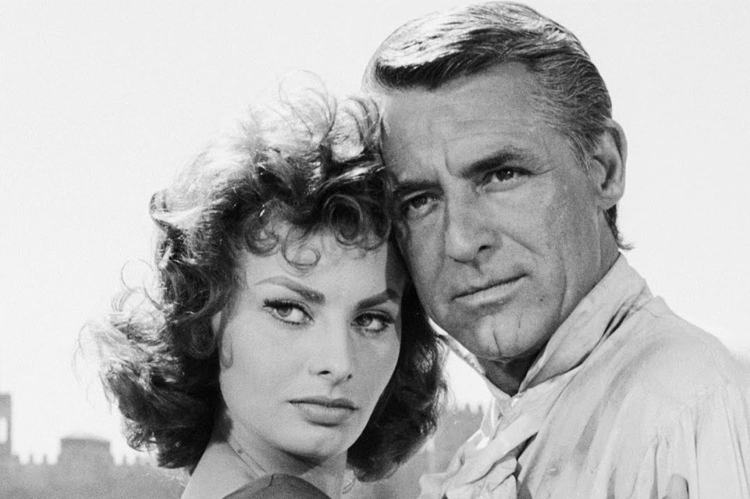 Sophia Loren und Cary Grant in Schwarzweiß, Köpfe nah, schauen in die Kamera.
