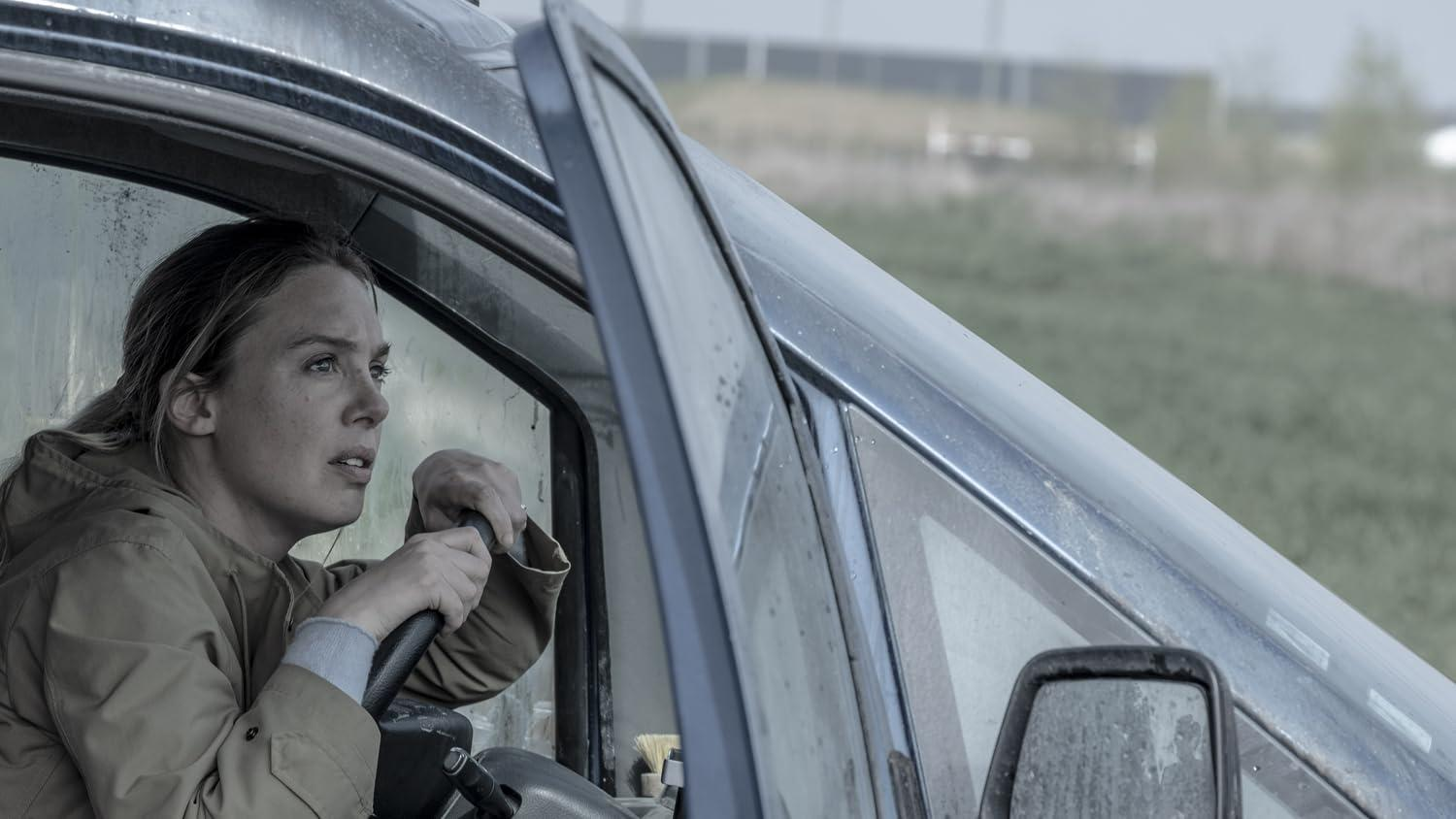 Eine Frau in einem Auto, die aus dem Fenster schaut.
