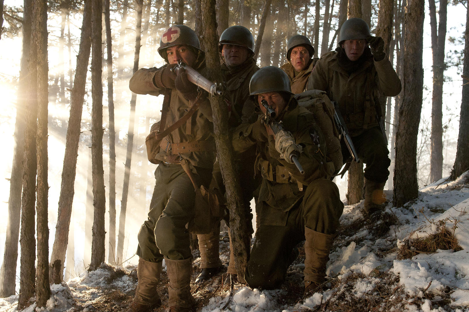 Soldaten im Wald mit Gewehren. Einige knien, andere stehen, Schnee am Boden.