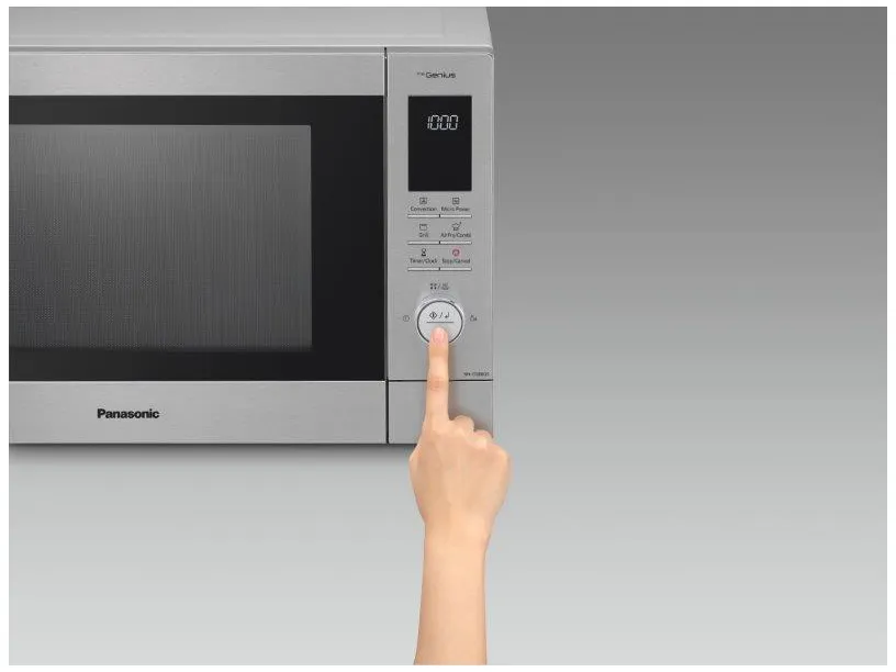 Una mano che preme un pulsante su un forno a microonde Panasonic argentato. Il display mostra '10:00'.