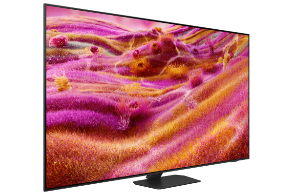 TV ekranı, pembe ve sarı tonlara sahip canlı bir soyut görüntü gösteriyor. Hafifçe açılı.