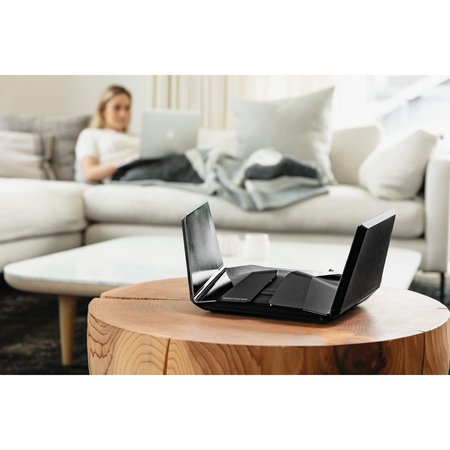 Vrouw op bank met laptop, router.