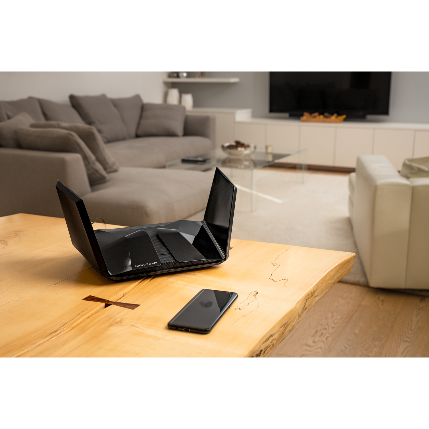Zwarte Nighthawk router en telefoon.