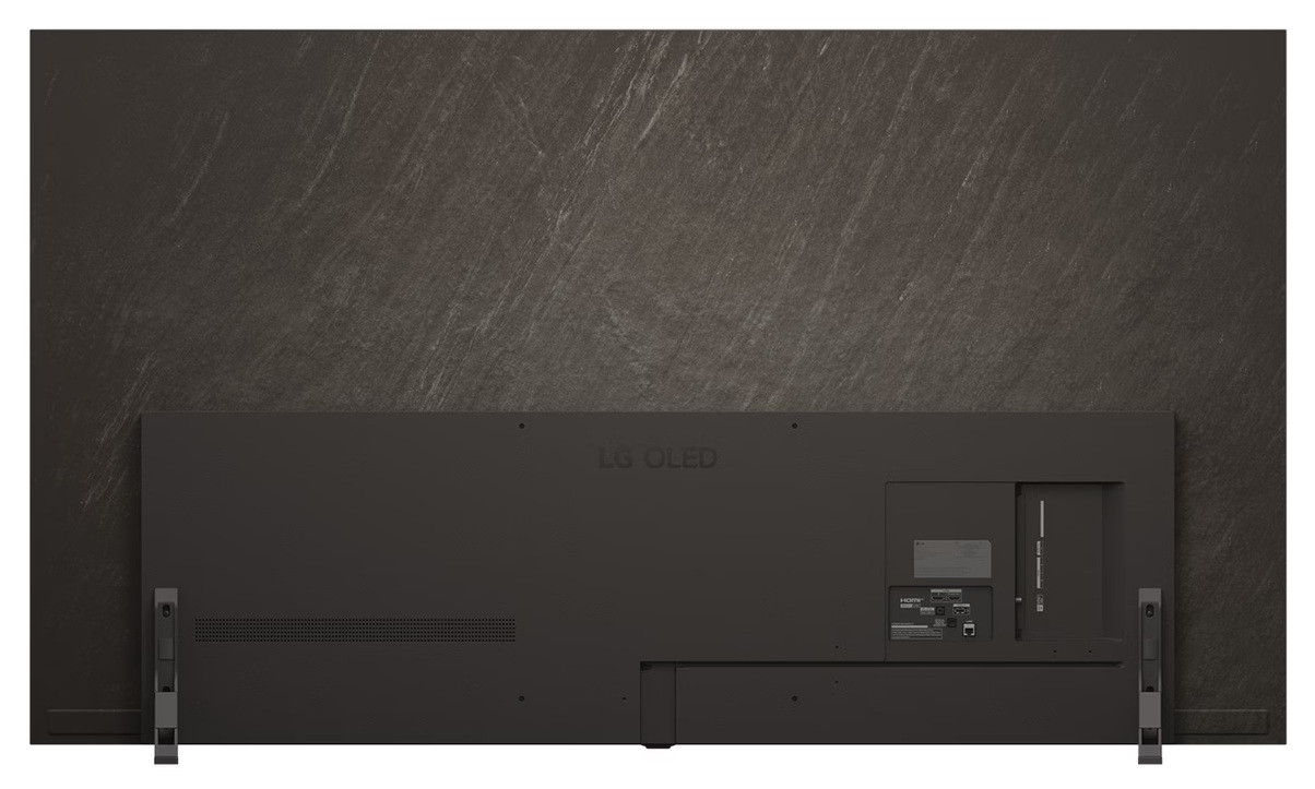 Widok z tyłu czarnego telewizora LG OLED z portami i podstawą. Za nim ciemnoszara teksturowana ściana.