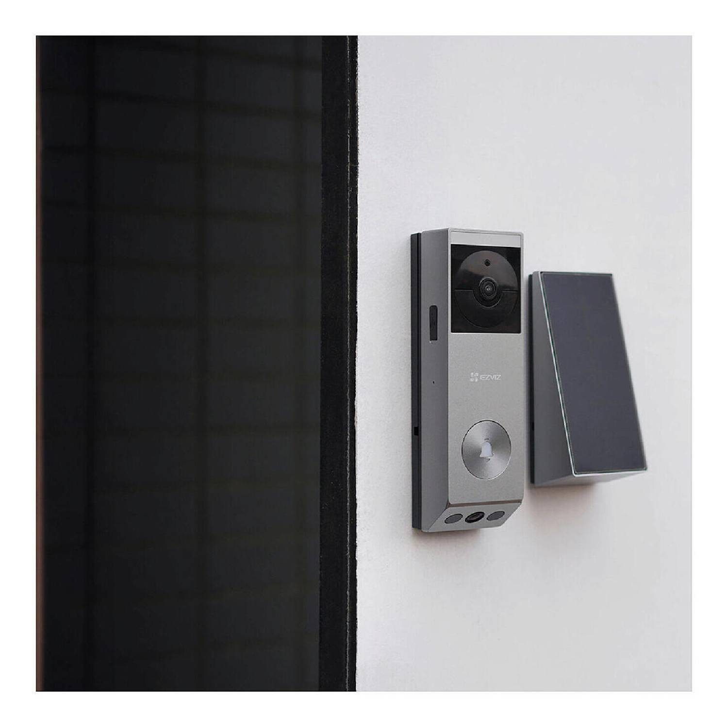 Une sonnette intelligente argentée est fixée sur un mur blanc. Elle possède une caméra et un bouton. À côté, un écran noir.