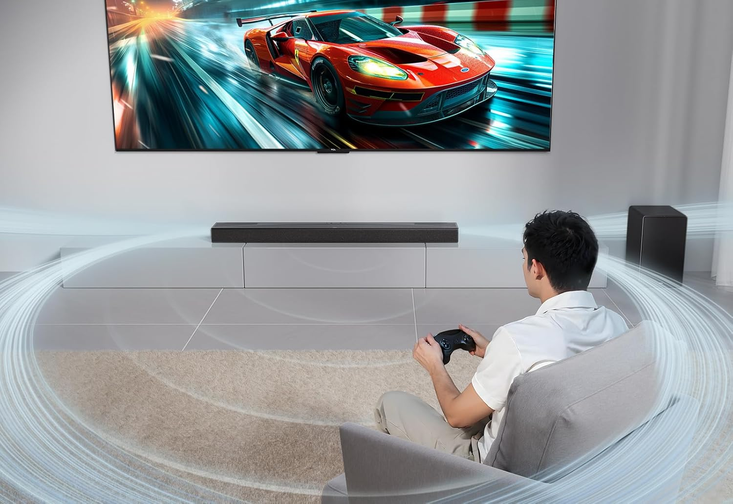 Un hombre jugando un videojuego con una barra de sonido en la mesa.