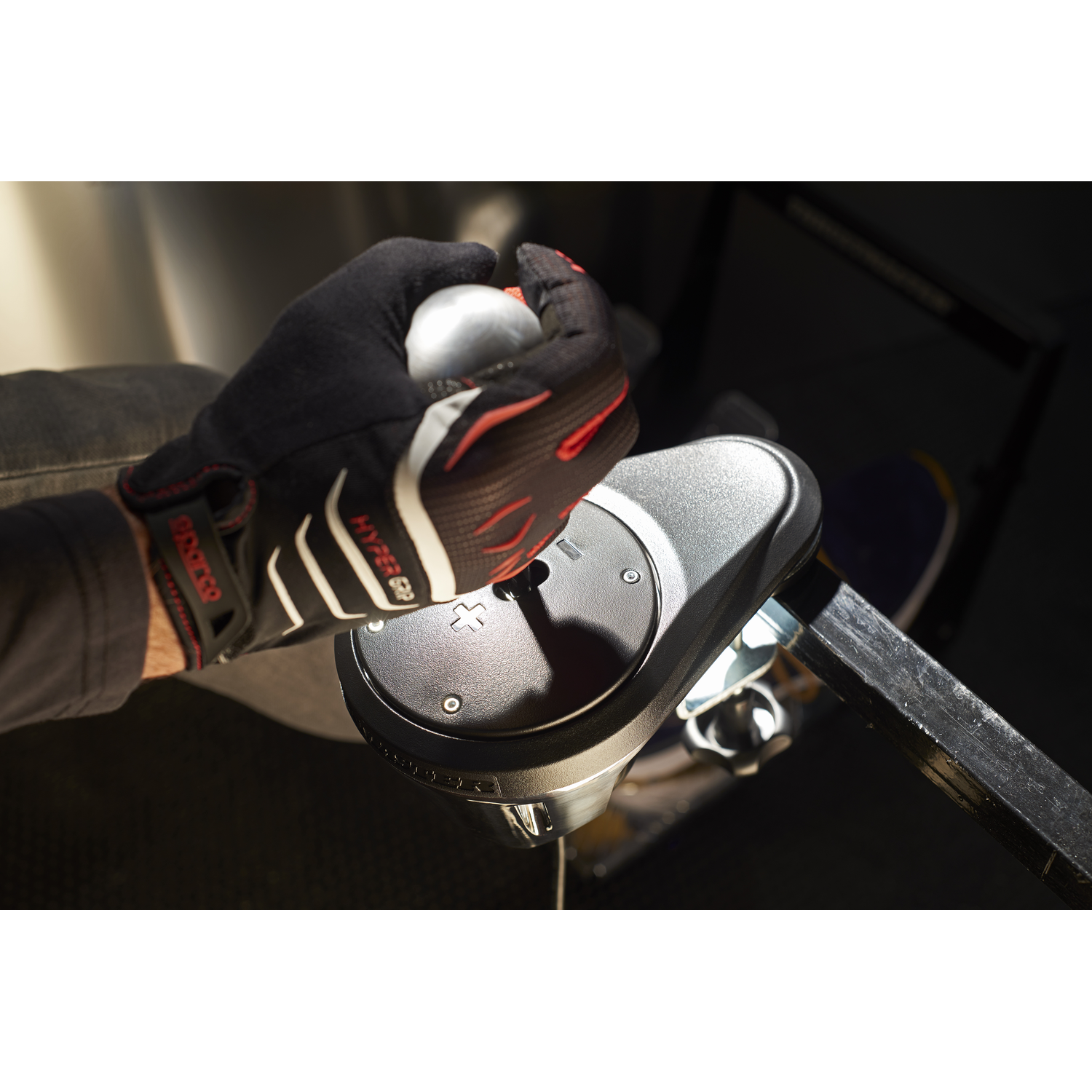 Hand holding a silver gear shift knob in a car.