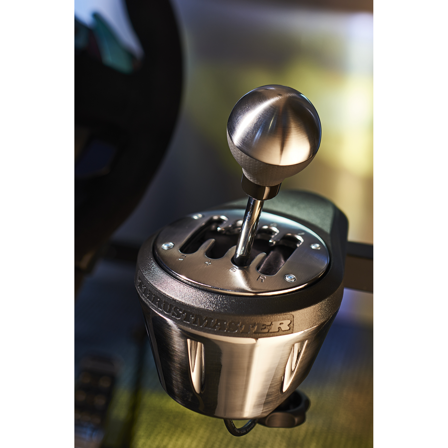 Close-up of a car gear stick. Silver ball on black base, with gear markings.