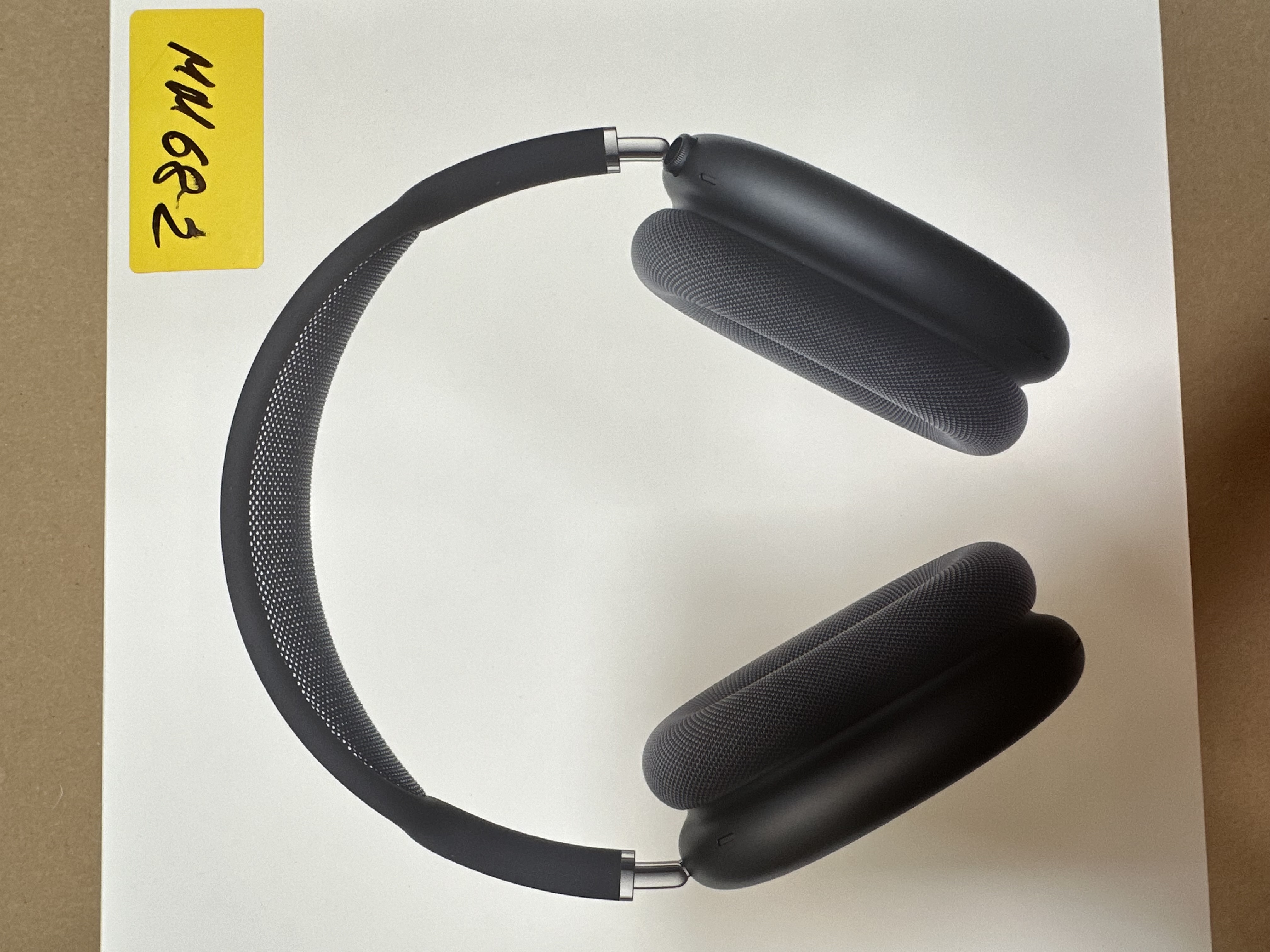 Słuchawki Apple AirPods Max na białym pudełku. Na pudełku żółta naklejka z czarnym tuszem.