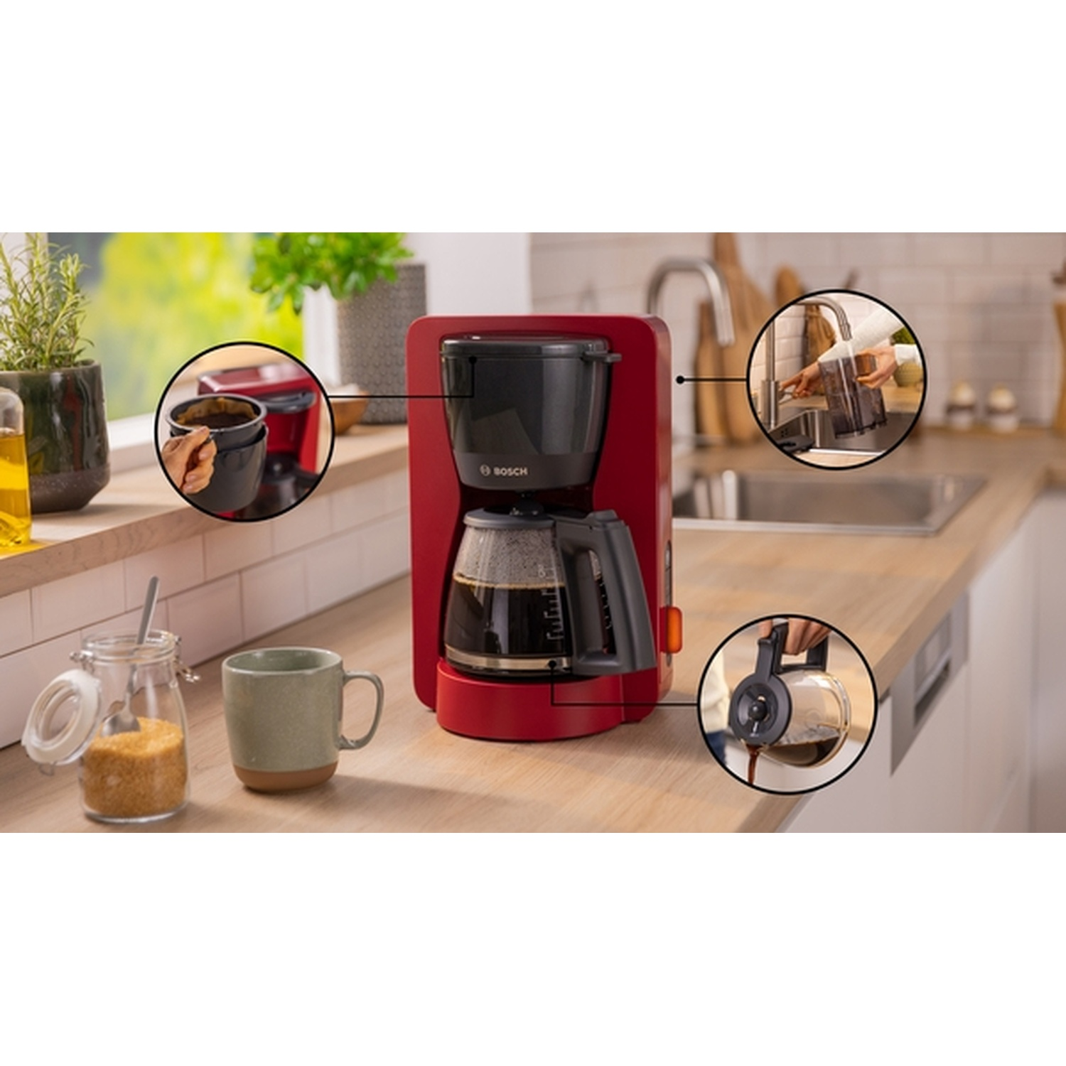 Una scena di cucina con una caffettiera rossa, tazze di caffè, zucchero e una persona che versa il caffè. Bancone in legno.