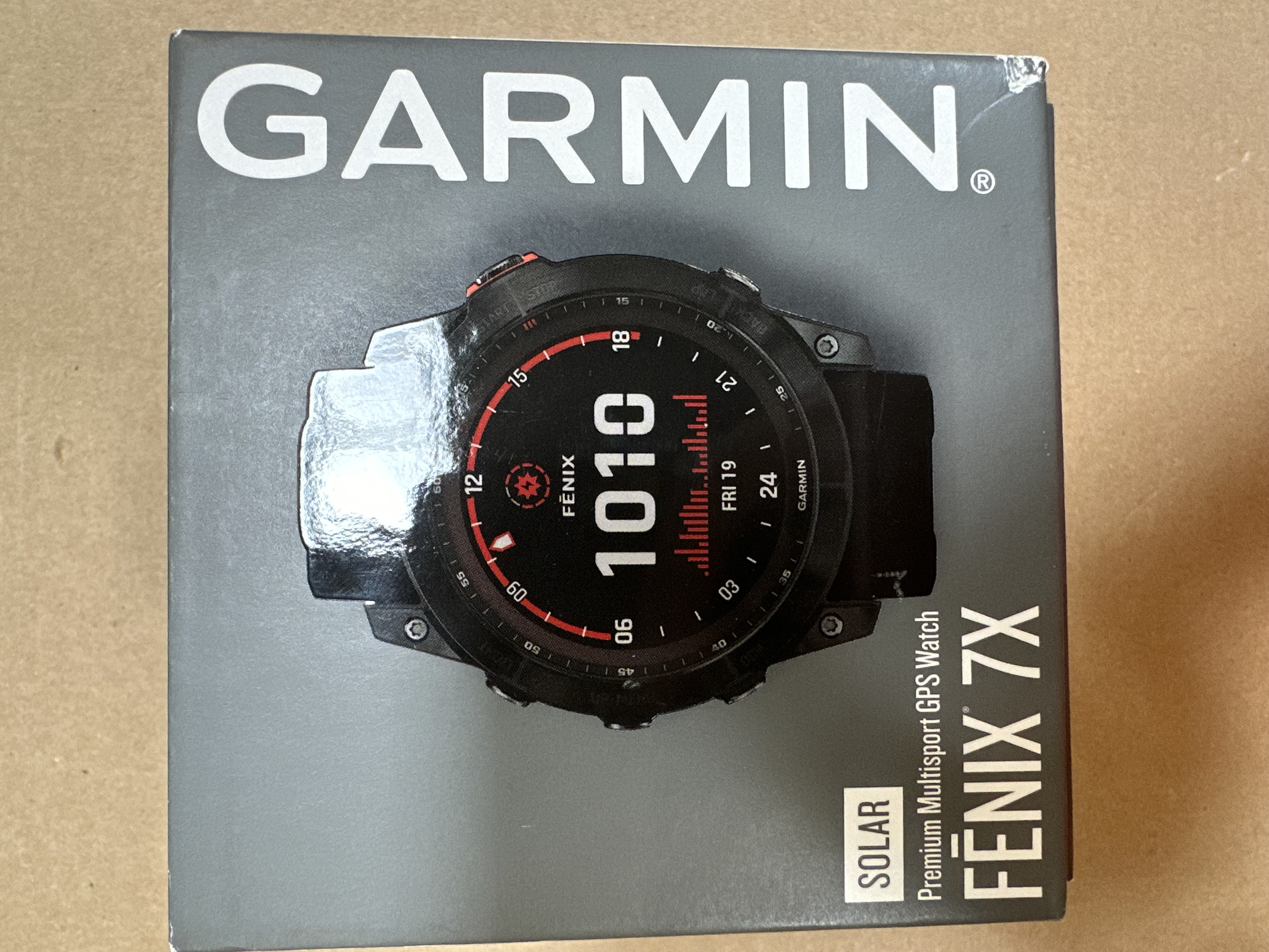 Zegarek Garmin Fenix 7X w szarym pudełku, widoczna tarcza.
