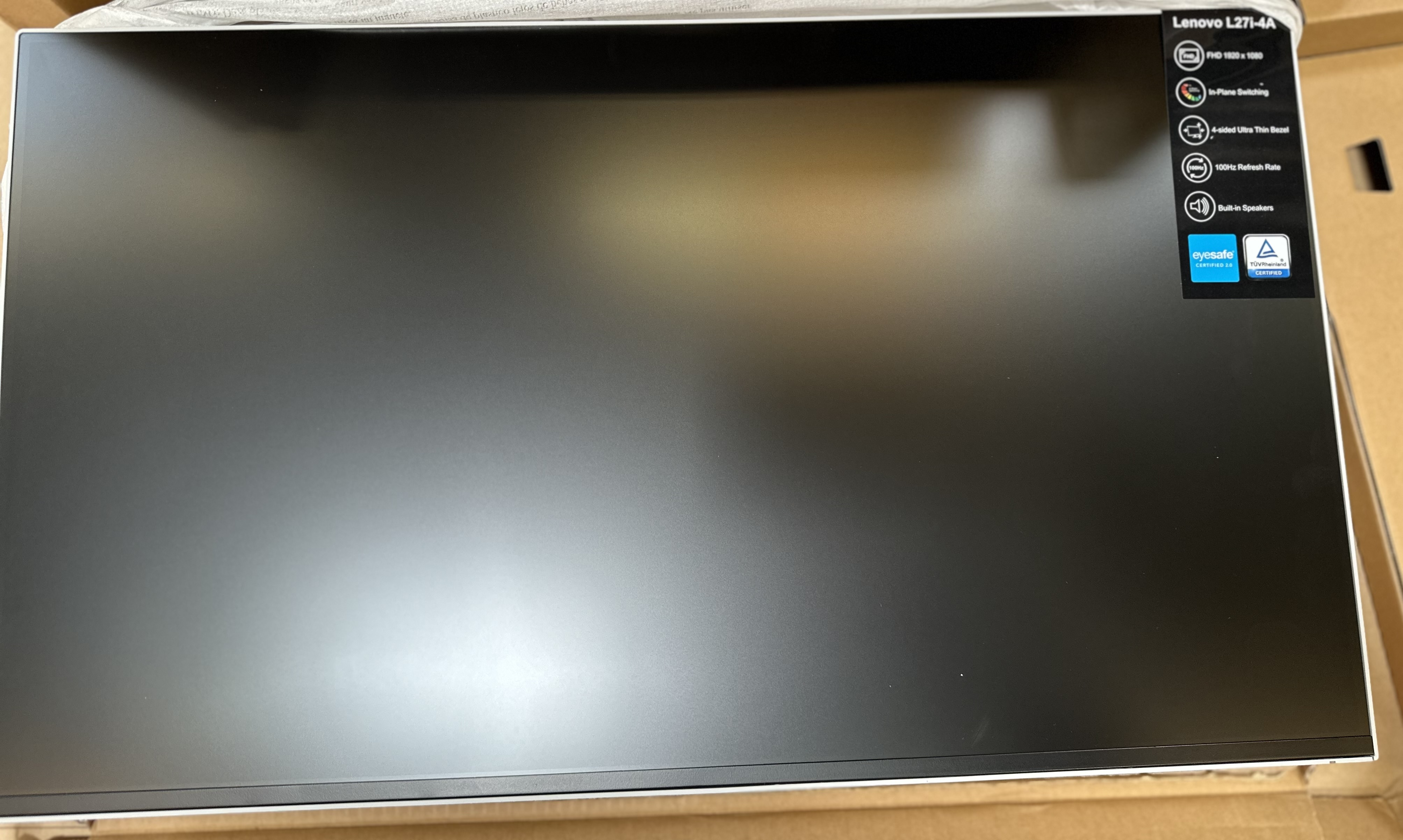 Rozpakowany monitor Lenovo, czarny ekran, z FHD i cienką ramką.