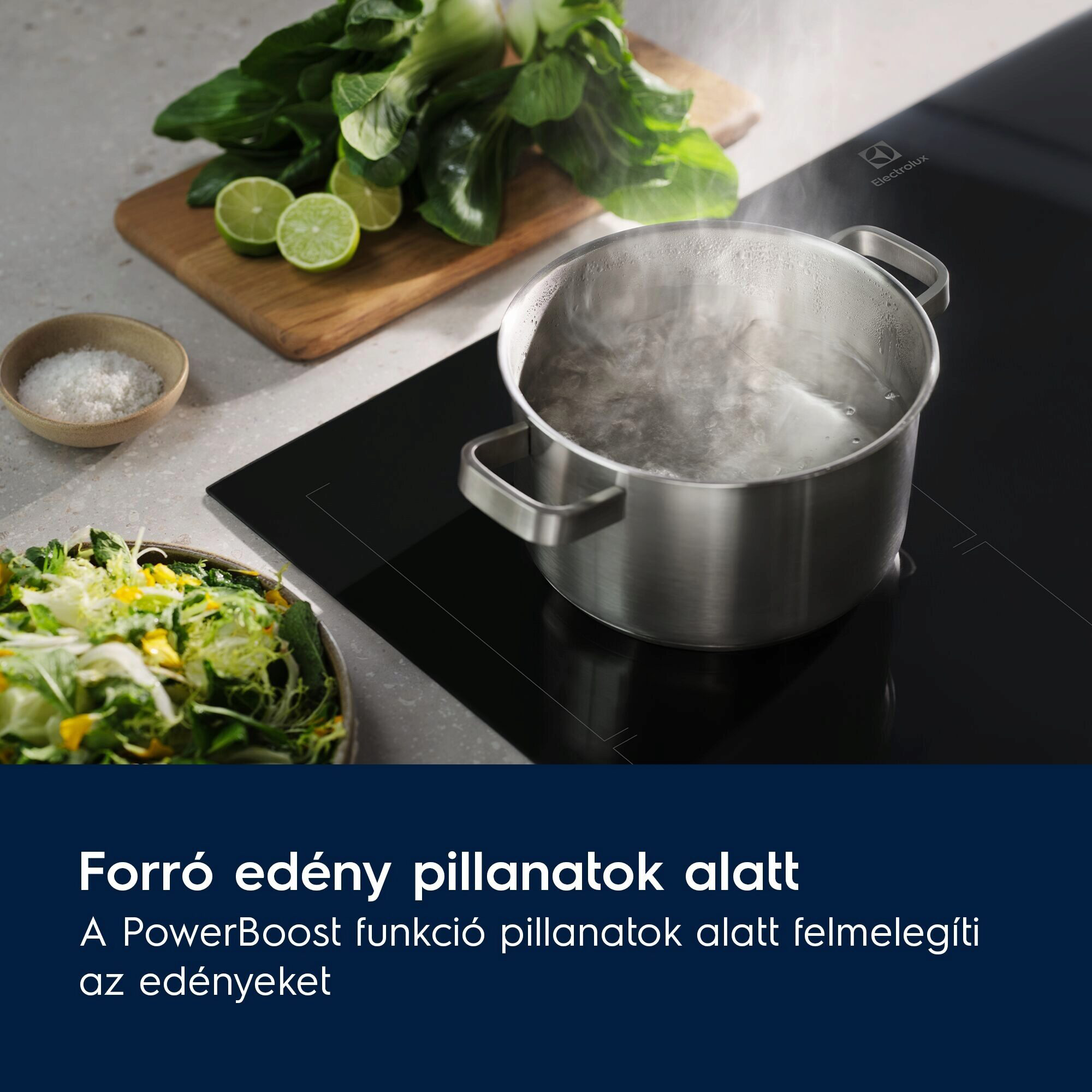 Forrásban lévő víz a fekete főzőlapon. Gőz emelkedik. Zöldségek és lime a háttérben.