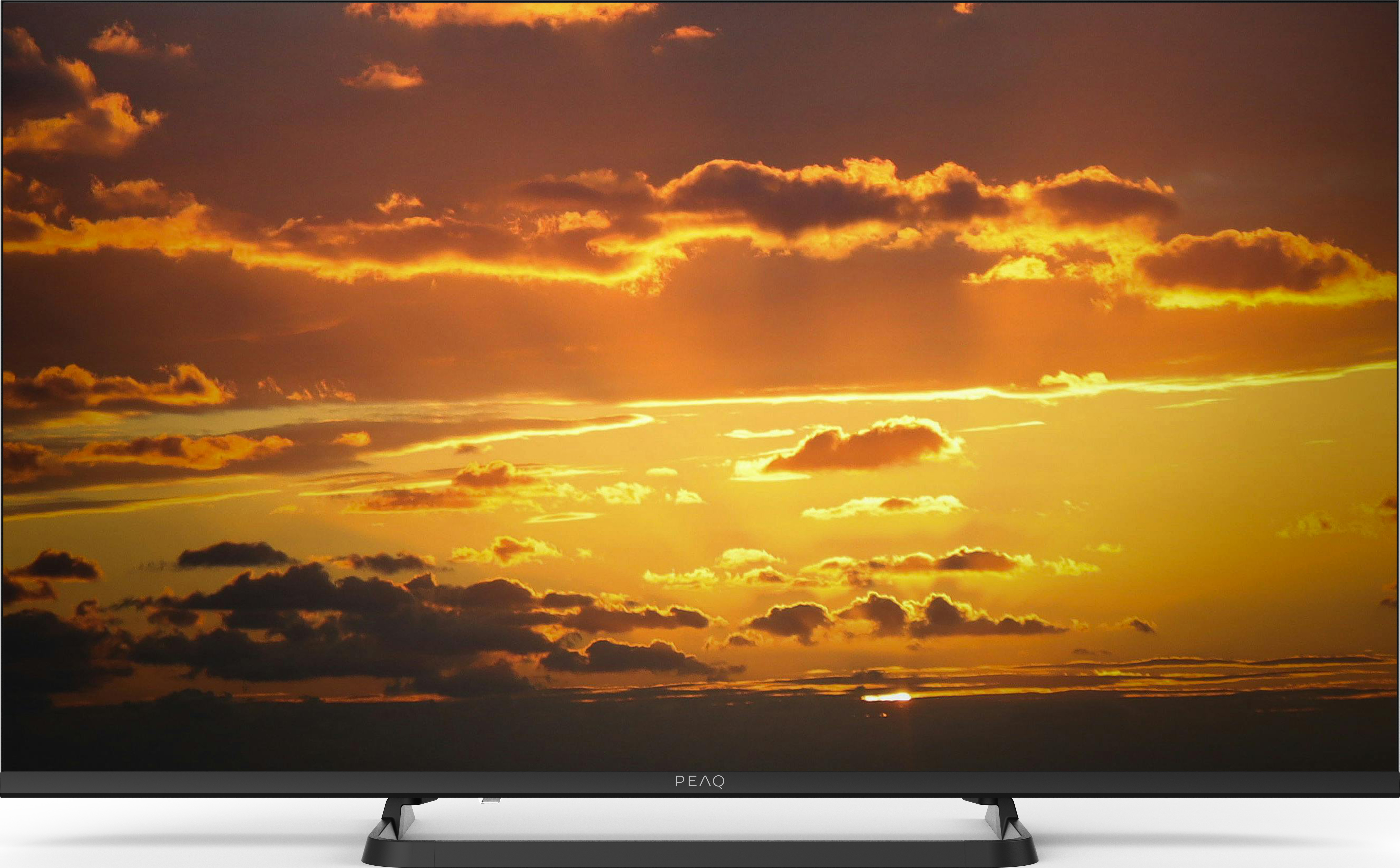 PEAQ-Fernseher zeigt eine Sonnenuntergangsszene mit Wolken.
