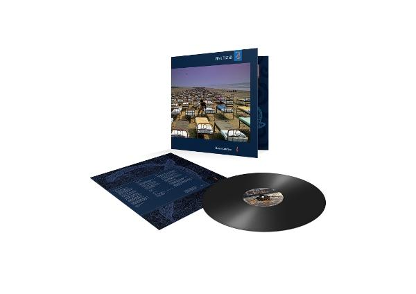 Pochette d'album avec une scène de plage remplie de lits, un disque vinyle et la pochette de l'album sur fond blanc.