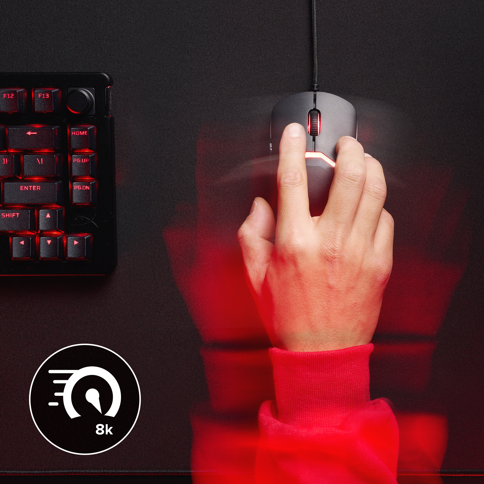 Hand using a black computer mouse with red lighting, keyboard in the background.